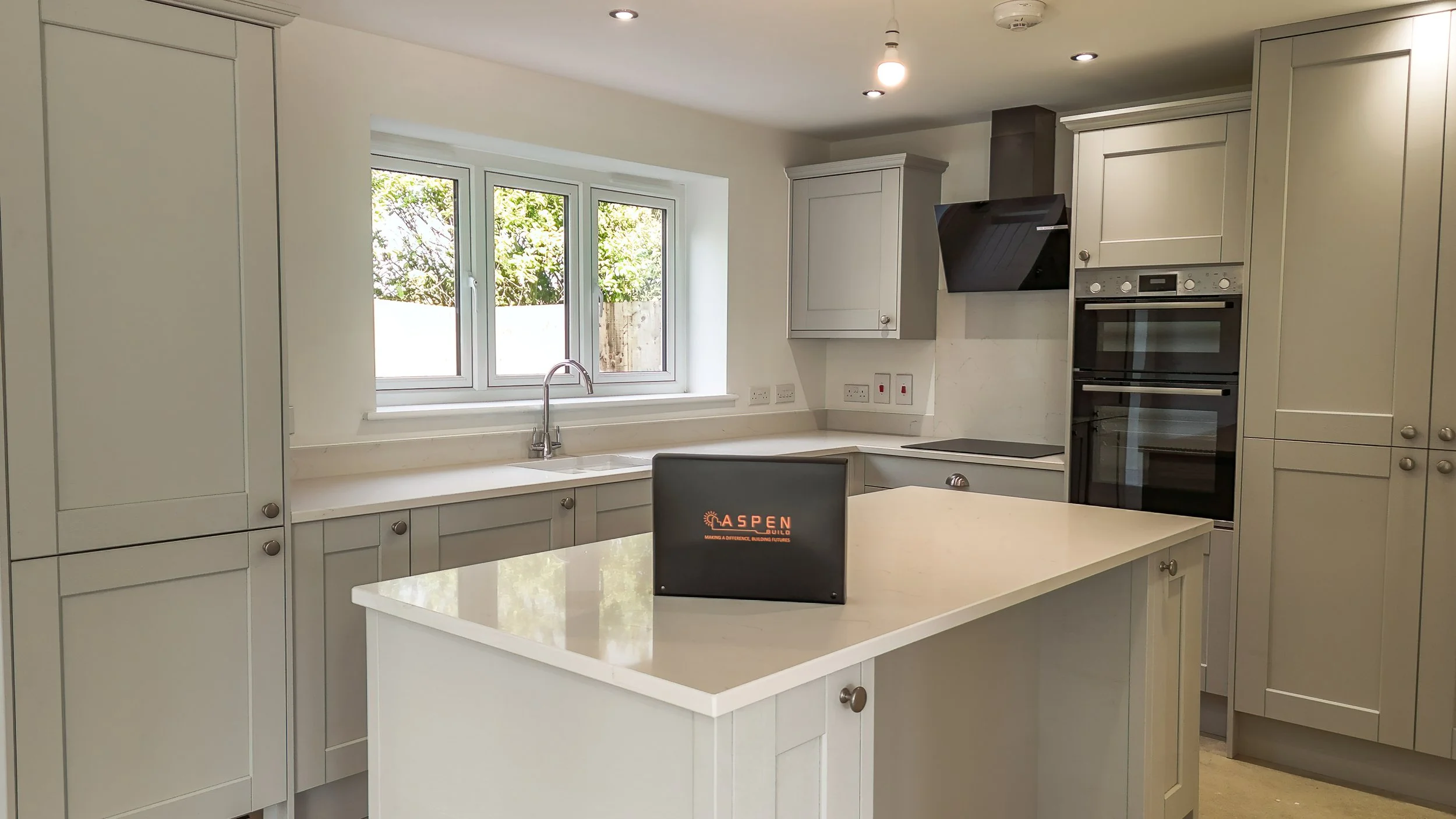 Fitted grey kitchen with central island at The Green