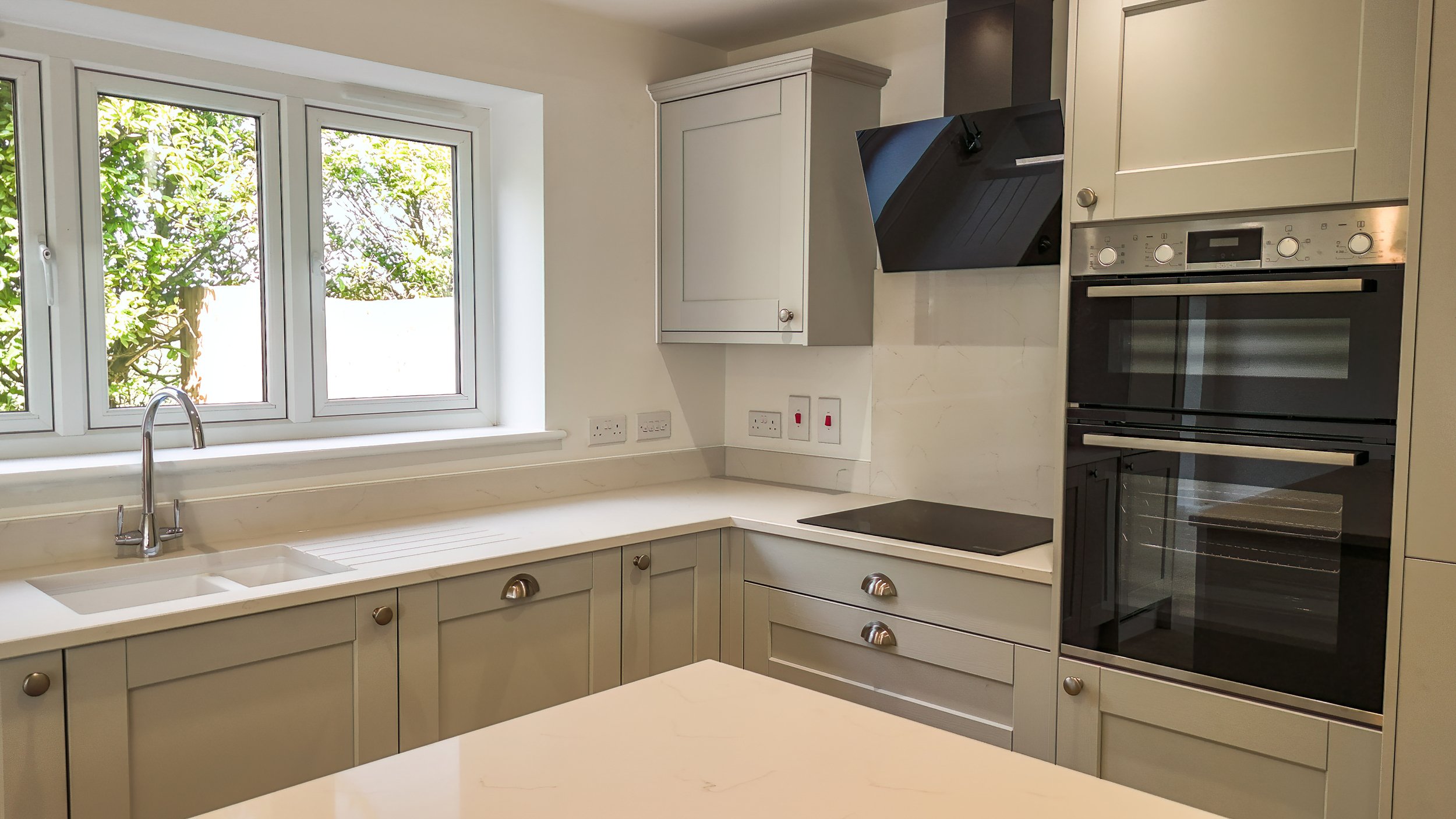 Grey fitted kitchen with integrated appliances at The Green