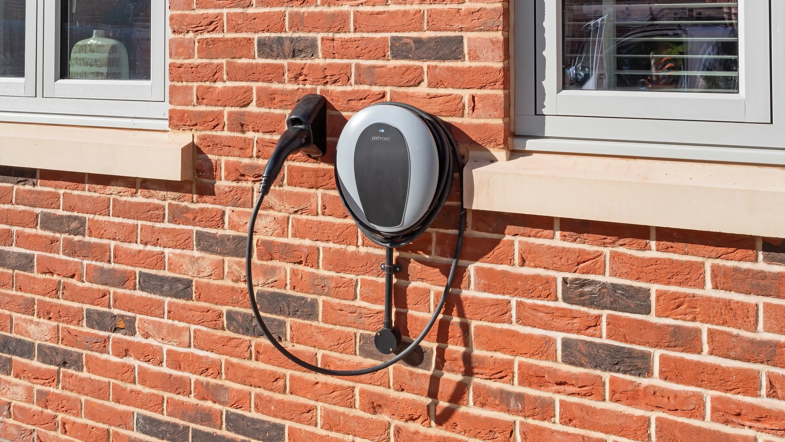 Electric vehicle charging point on a red-brick home at The Green