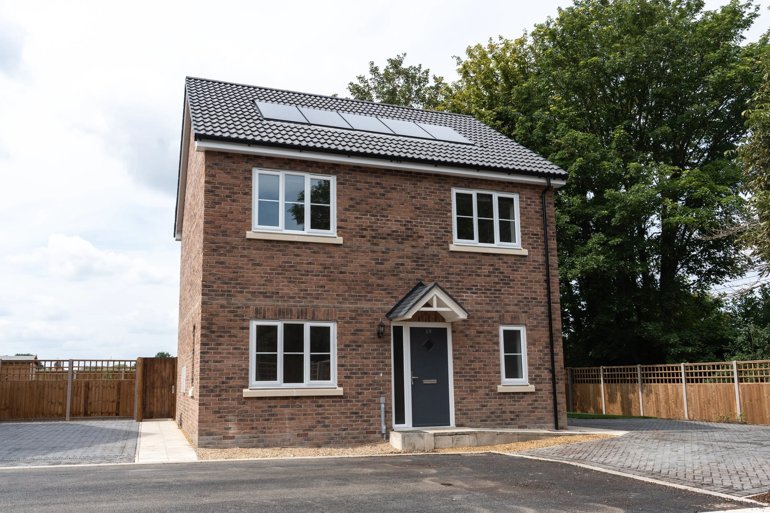 Detached brick home with roof-mounted solar panels at Gowers Place