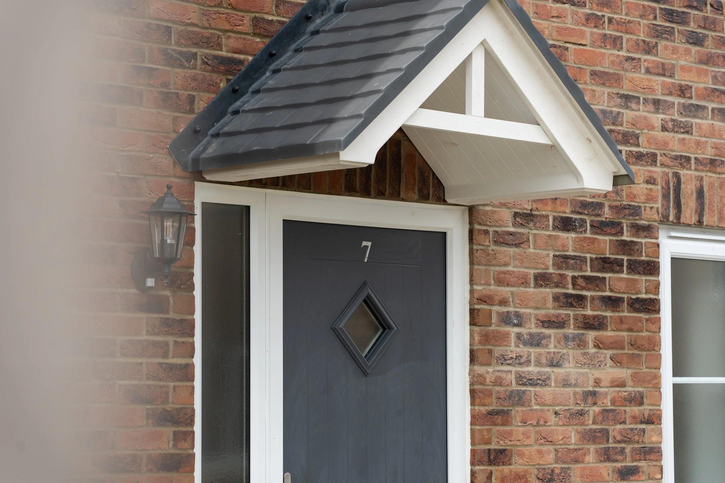 Grey front door and gabled canopy at Gowers Place