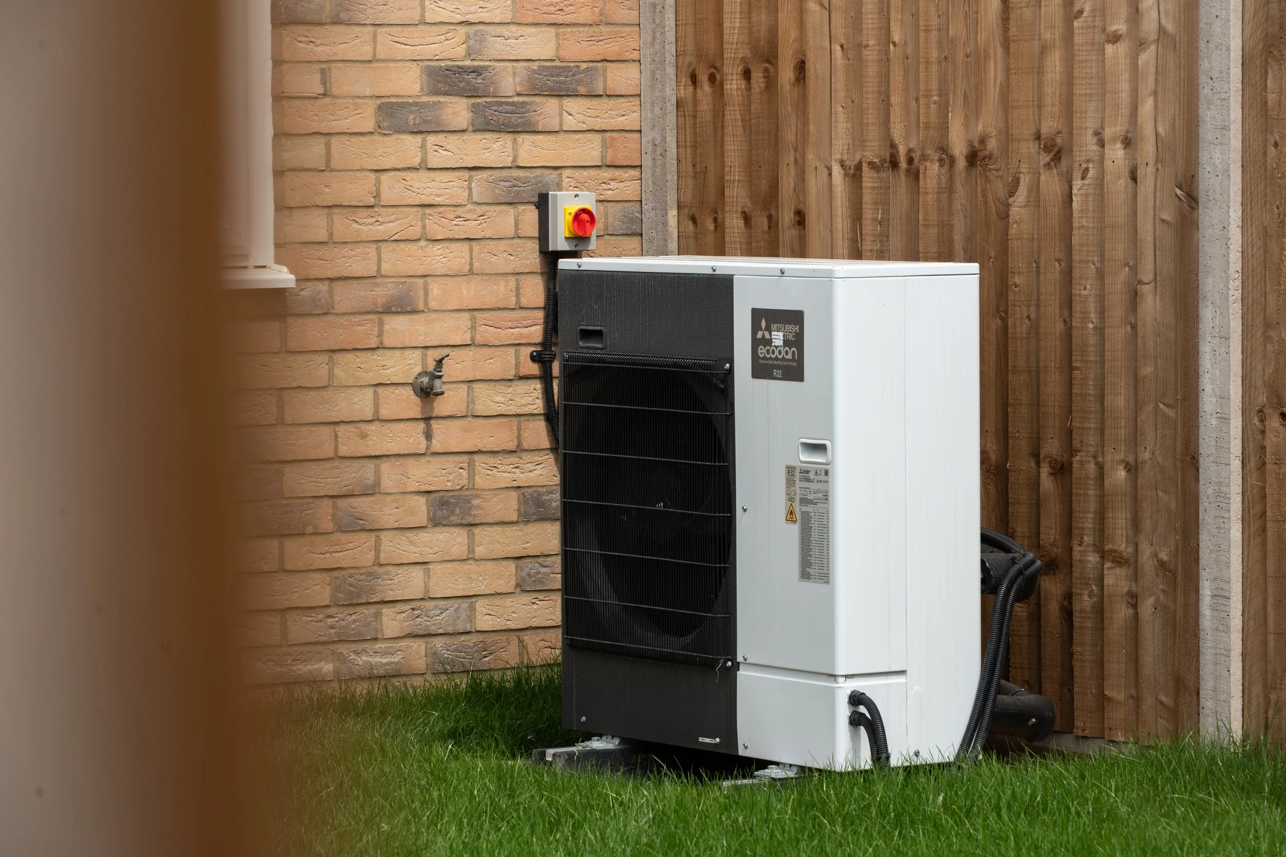 Air-source heat pump beside a home at Gowers Place