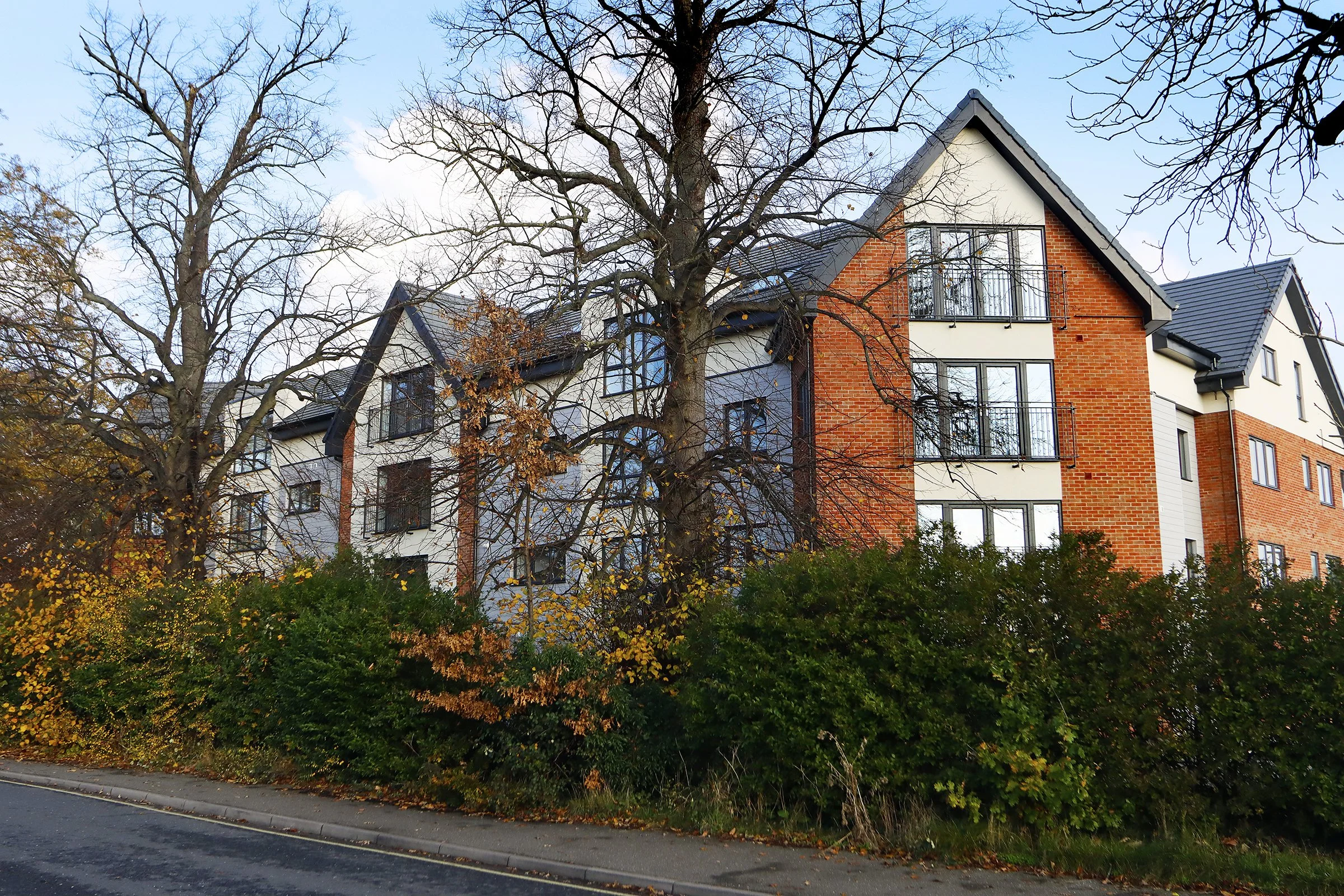 Wade House apartment building framed by mature trees in Stowmarket