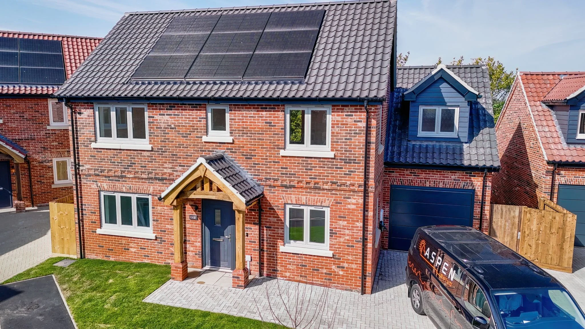 New brick-built home with solar panels and an Aspen Build van