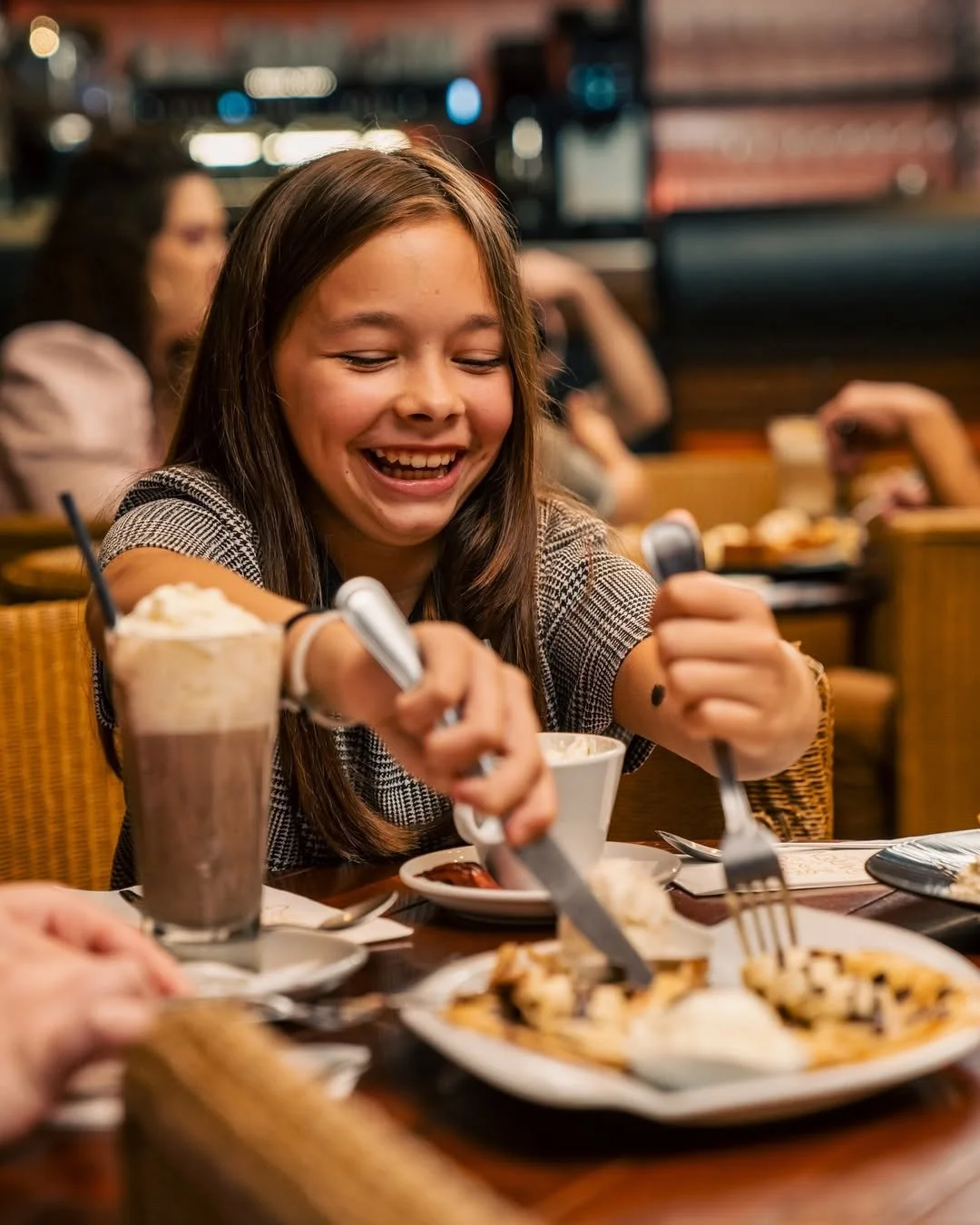 Une jeune fille souriante partage un repas avec d'autres personnes au Garden Ice