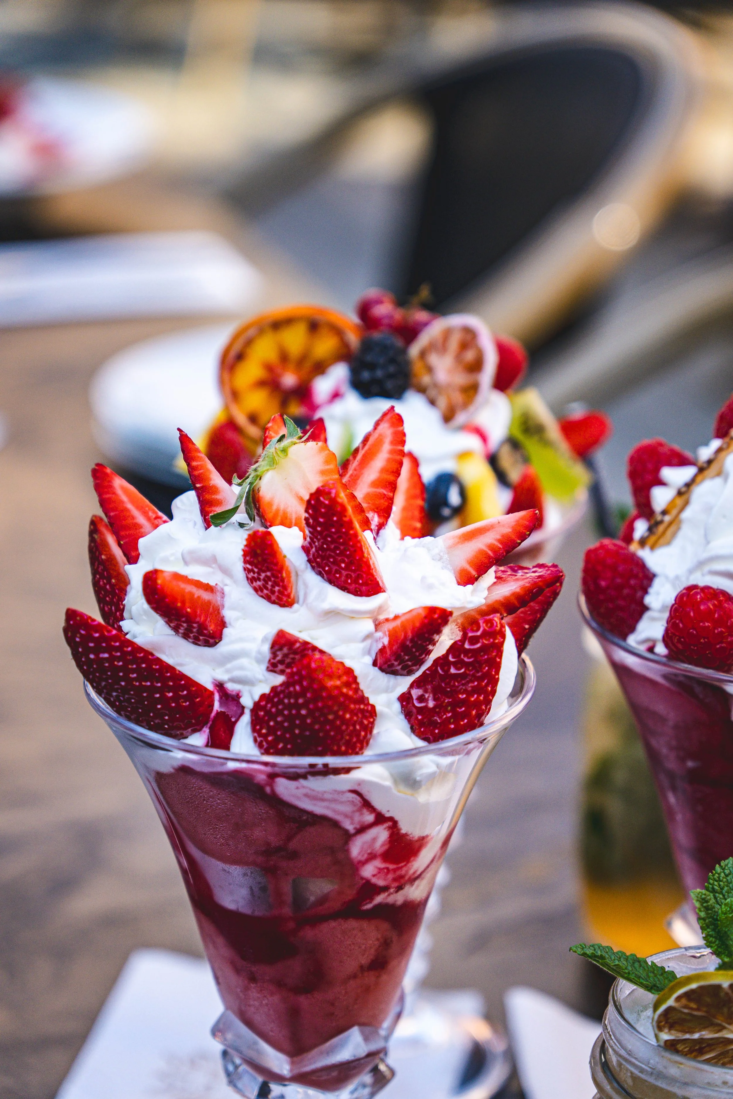 2 cocktails qui s'entrechoquent au dessus de deux coupes de glaces  