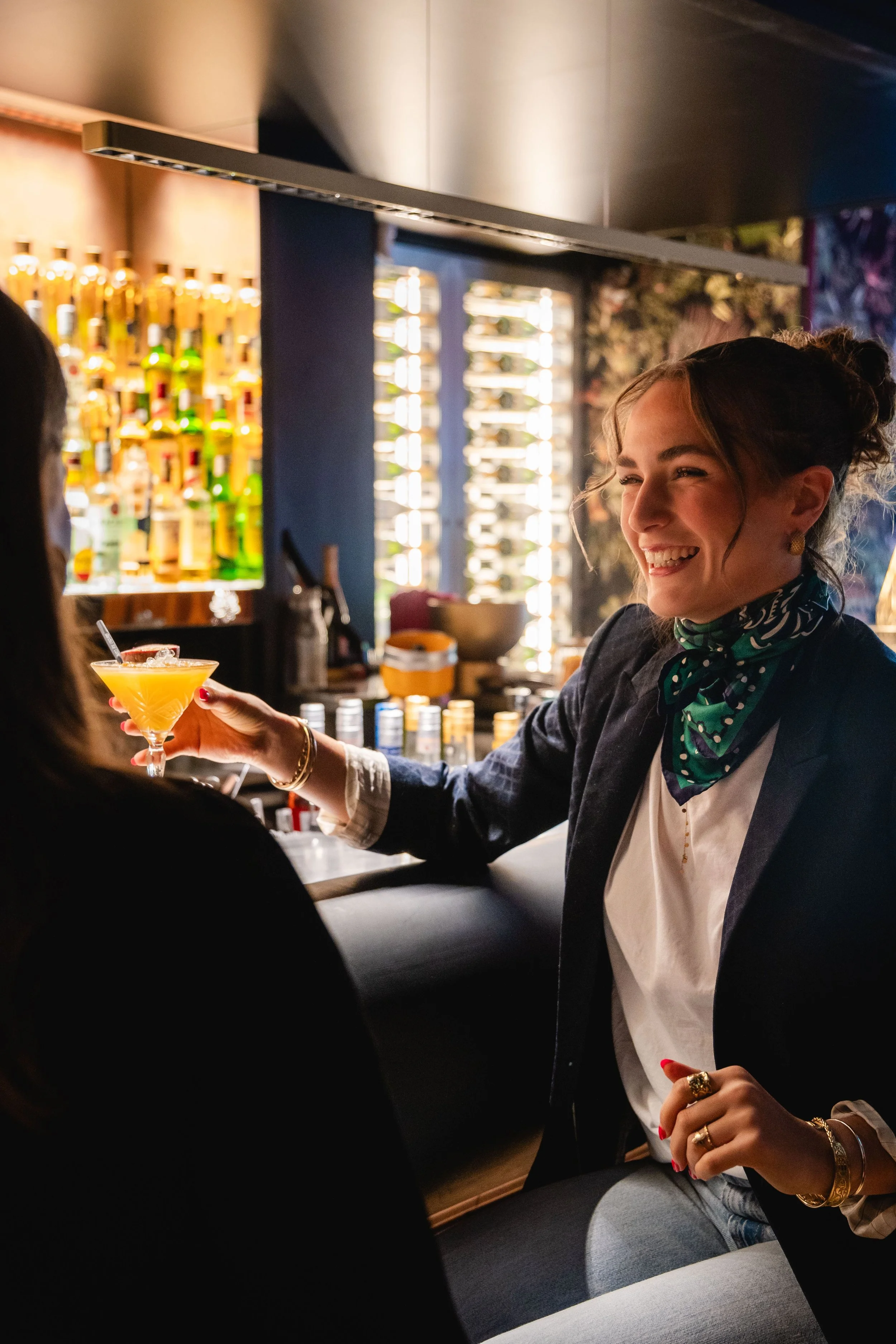 Une femme souriante au bar du Garden Ice Café avec un cocktail