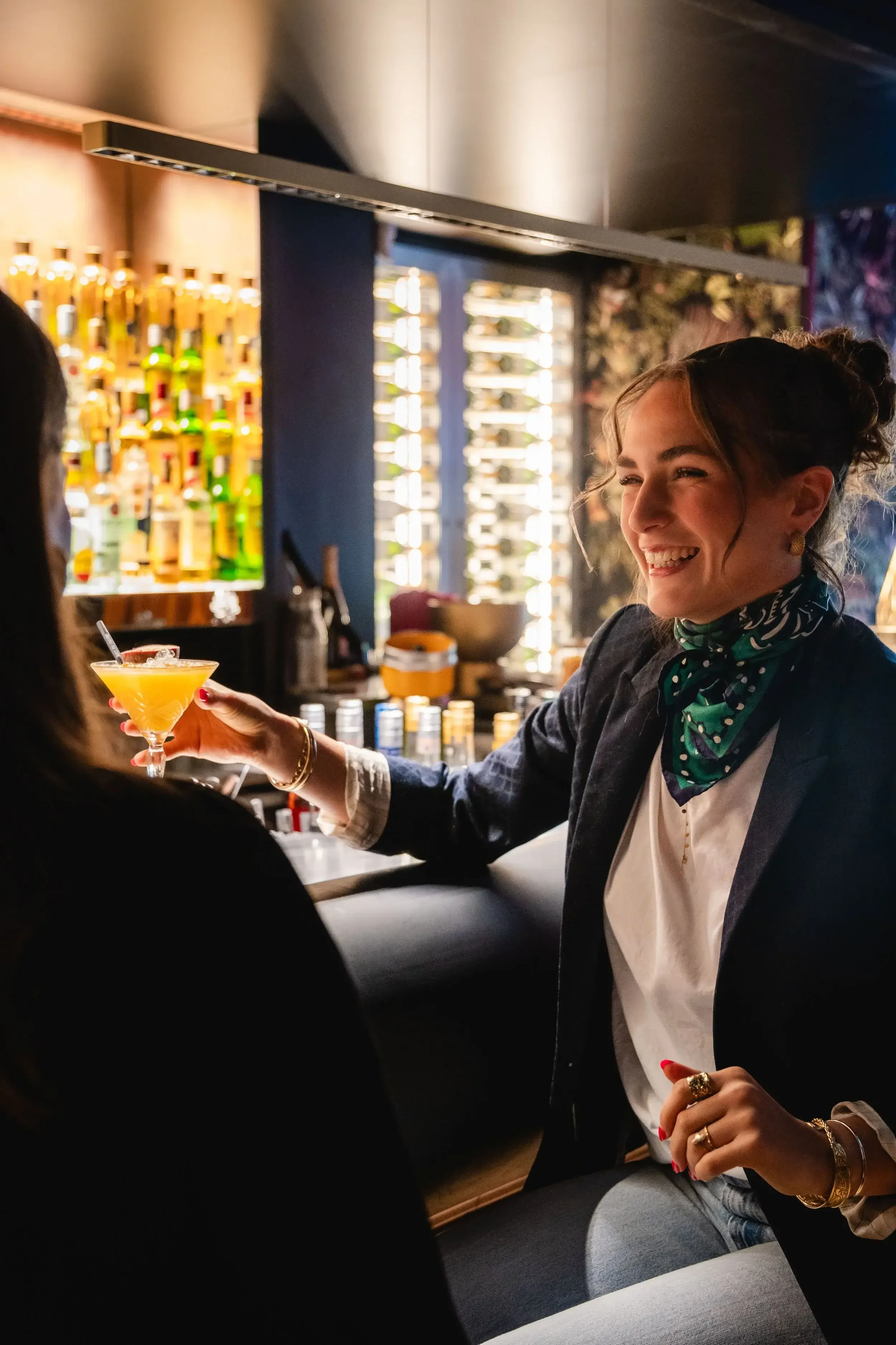 Une femme souriante au bar du Garden Ice Café avec un cocktail