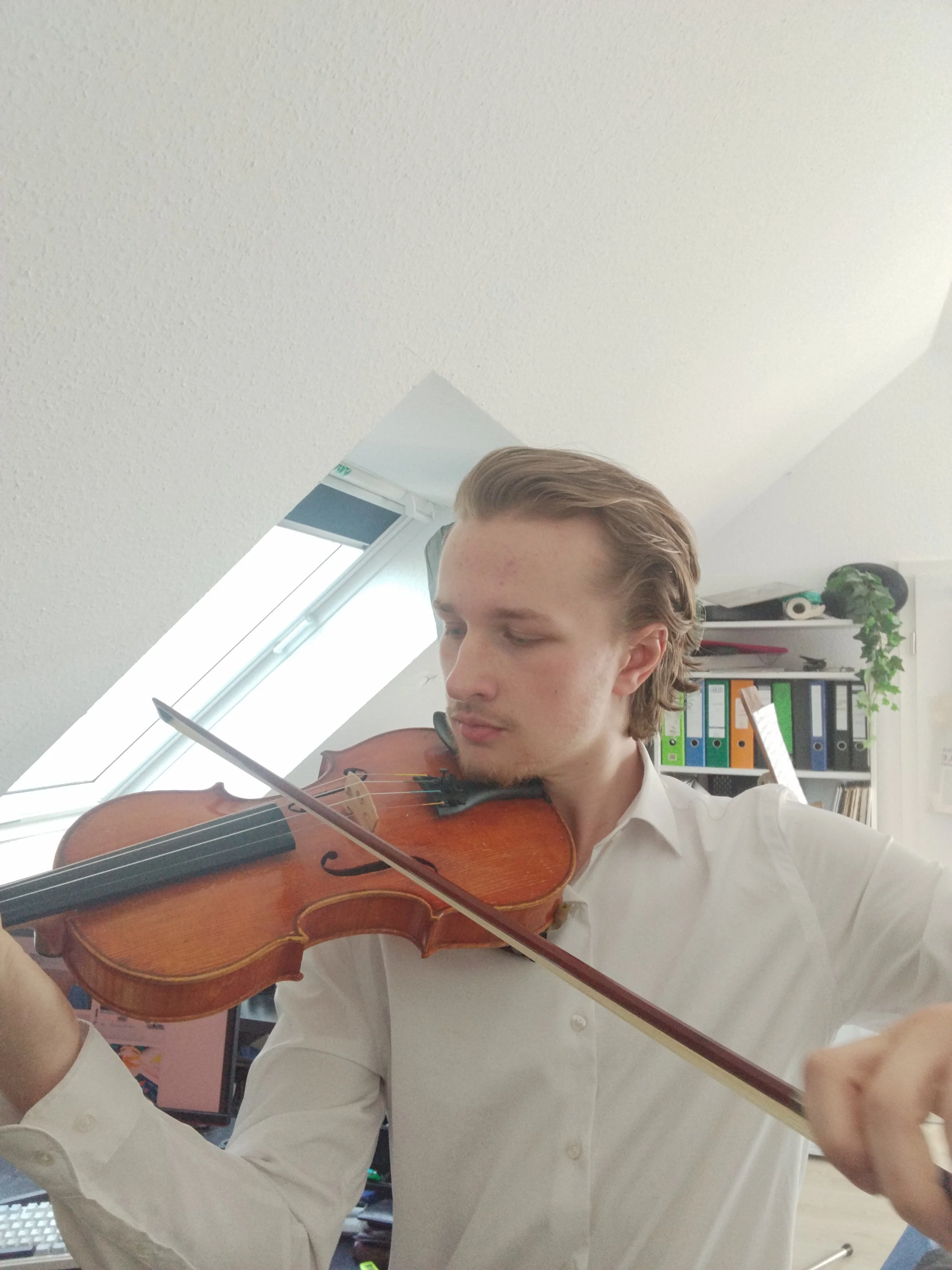 Geigenkonzert, Geigenauftritt, junger Mann Mika spielt in weißem Hemd auf einer Geige Schwanensee
