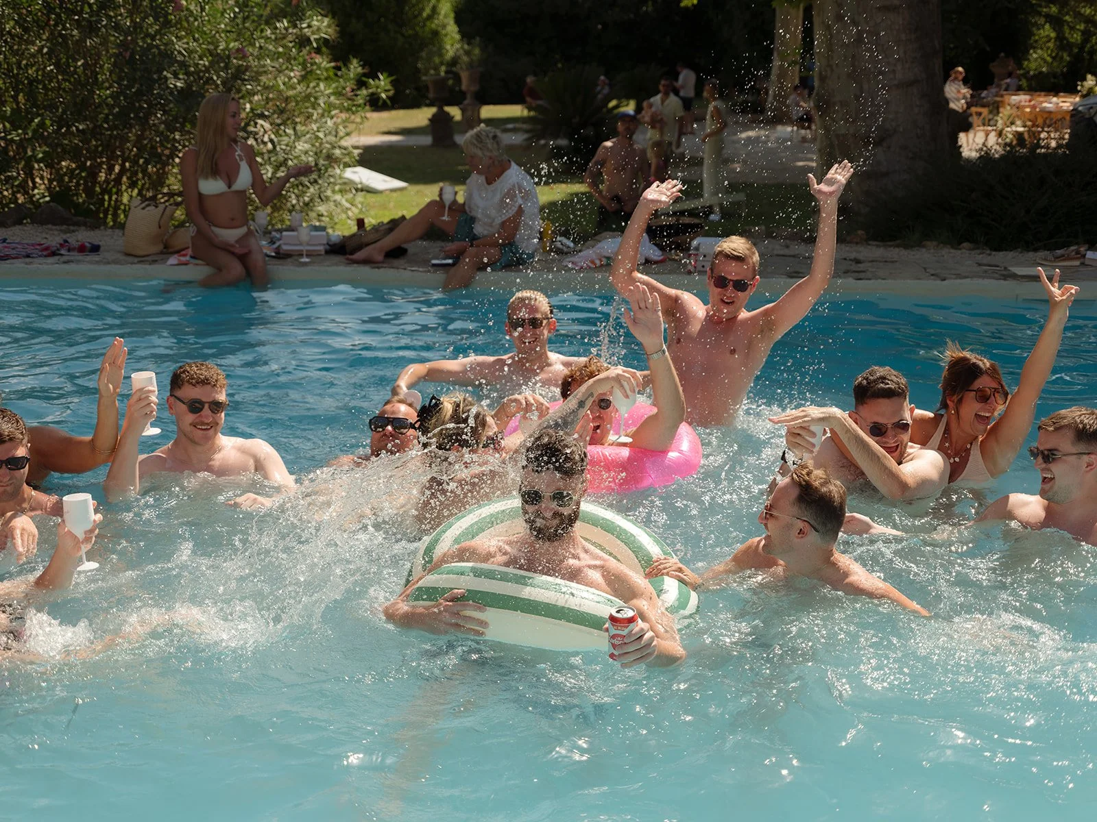 image of friends enjoying a pool party the day after a wedding, splashing in the pool at chateau robernier