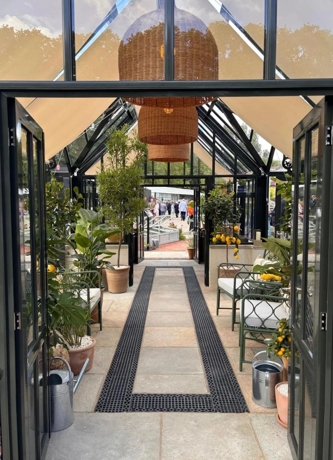 Glasshouse designed by Richardson & Veale with three large rattan pendants and traditional garden furniture with handmade cushions