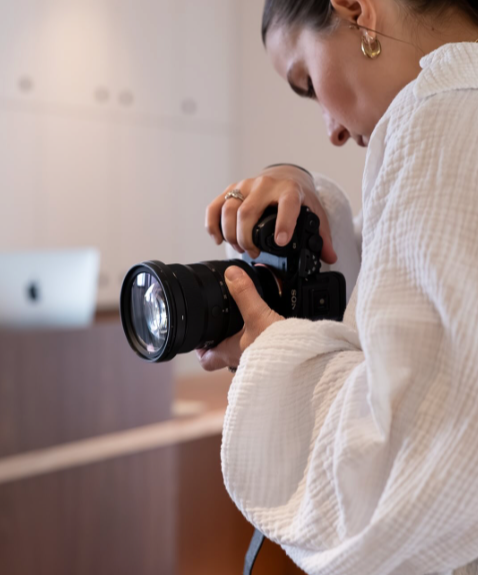 Une femme tenant un appareil photo, prête à prendre une photo.
