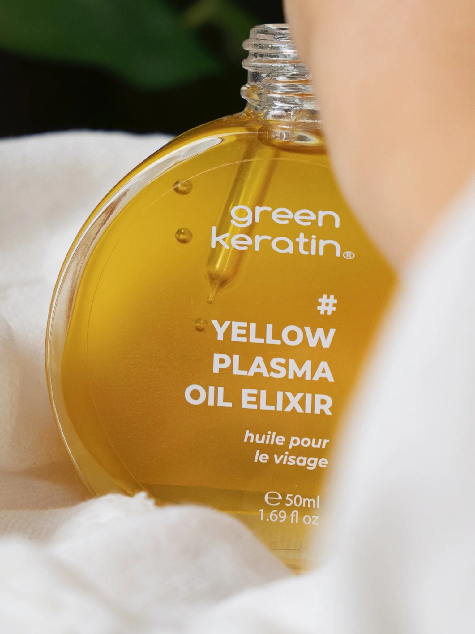 Flacon d'huile pour le visage avec étiquette indiquant huile de plasma jaune, 50 ml, produit de soin à base de kératine verte.