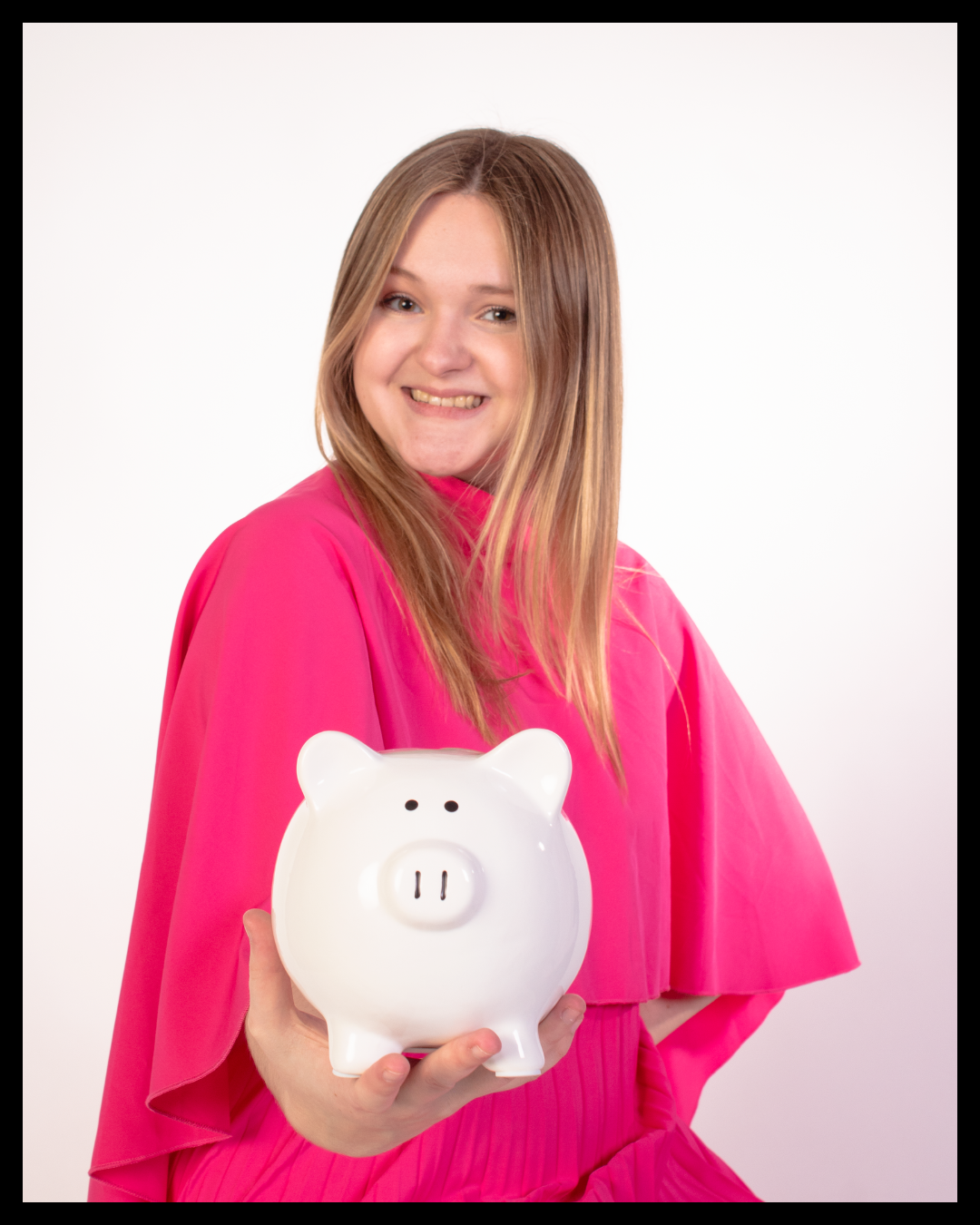 The founder of AJ Media Consulting, wearing a pink dress, smiles while holding a white piggy bank against a plain white background.