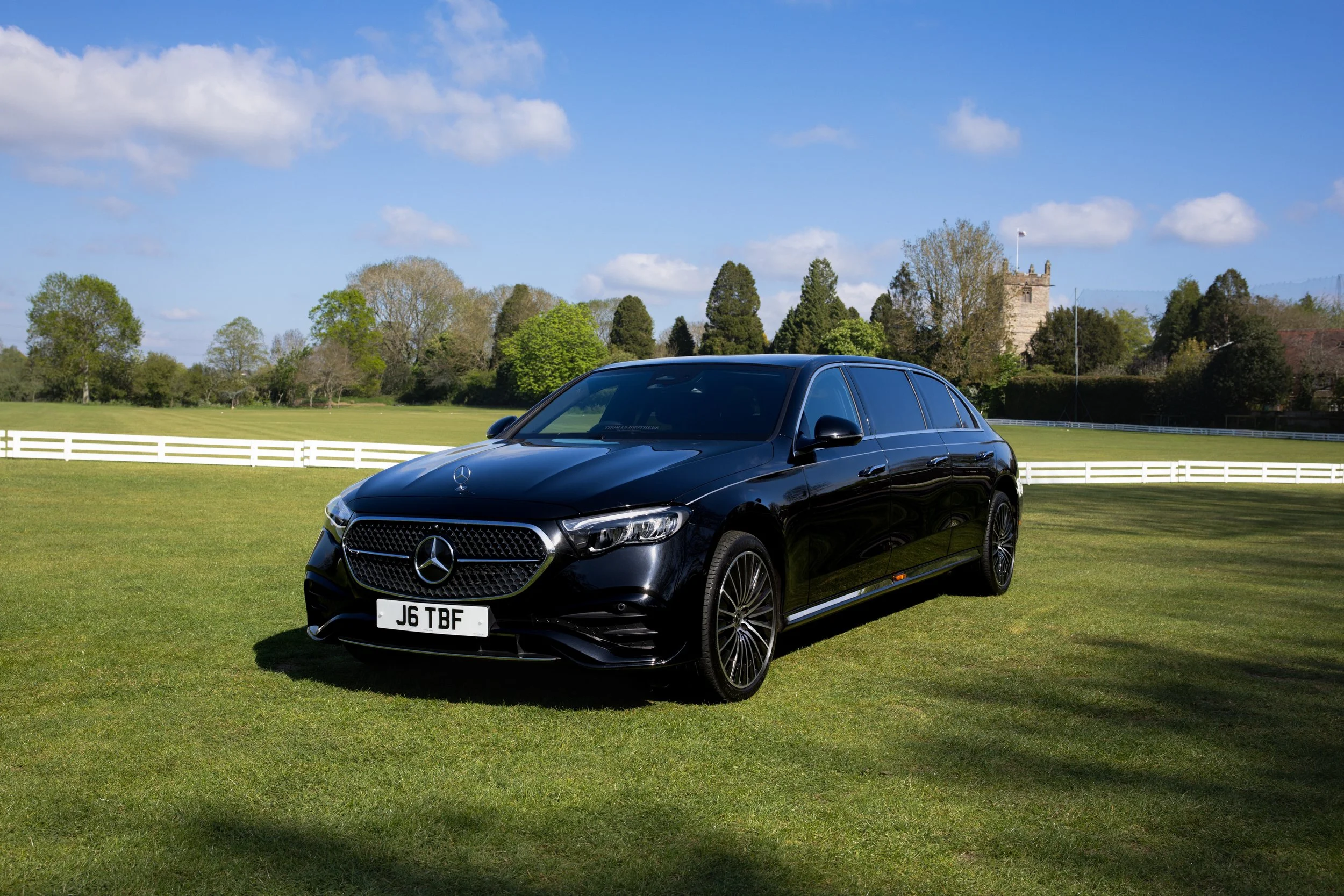 Thomas Brothers Funeral Directors based in south Birmingham and Worcestershire. A black Mercedes-Benz car parked on a grassy field funeral transportation.