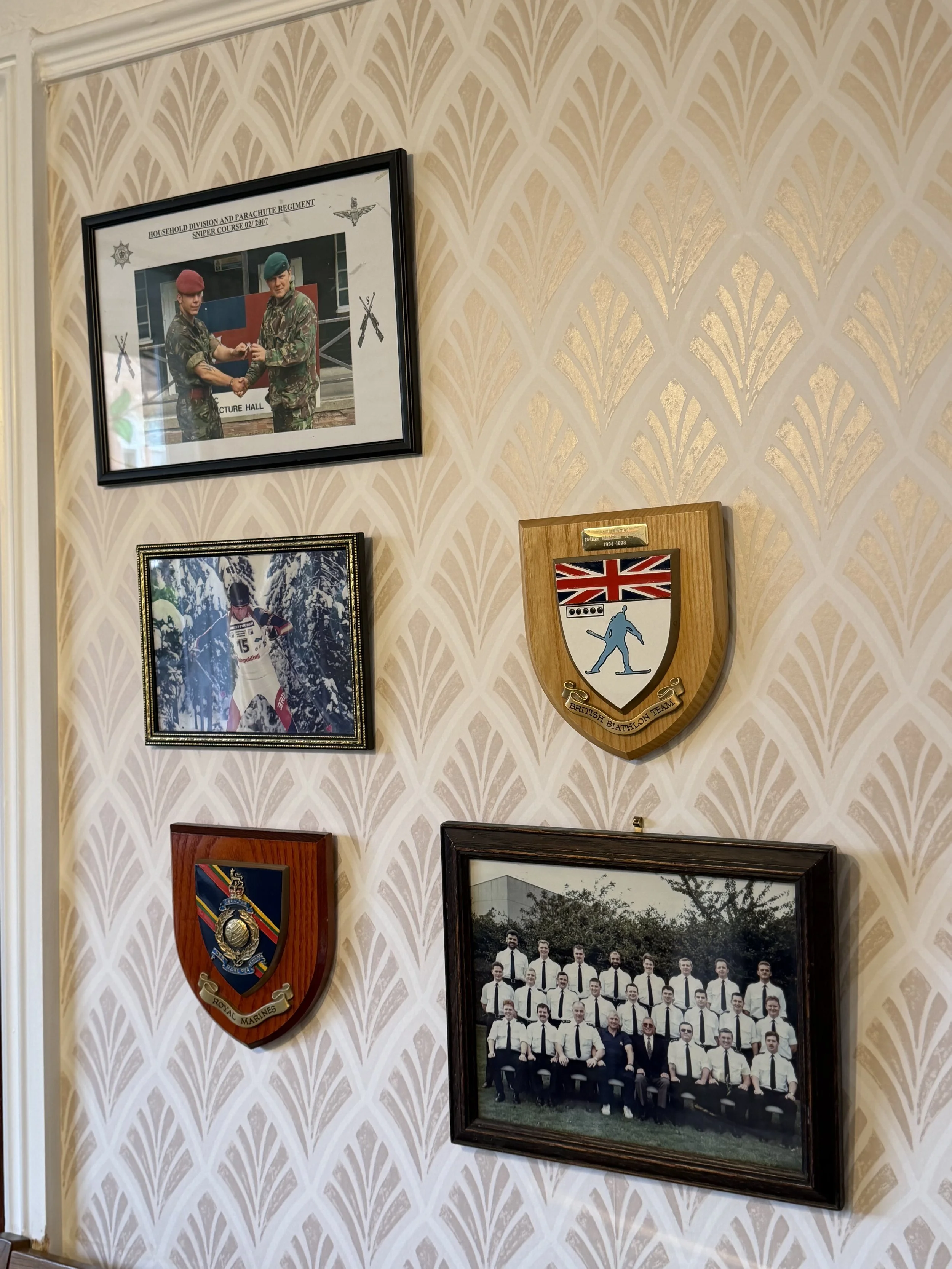 A wall decorated with framed photographs and military insignias, Thomas Brothers The Funeral Directors legacy