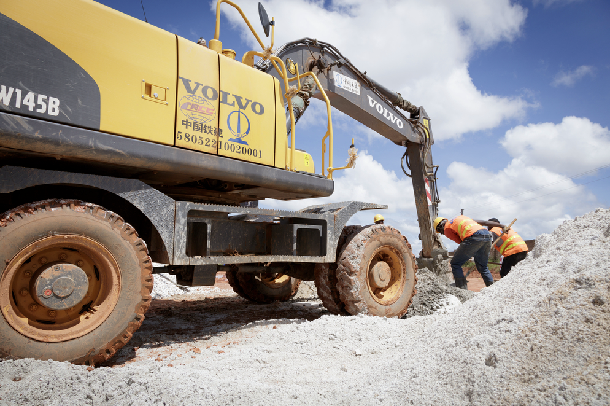 Construction workers working on Roma Park Commercial construction site, with blue sky and clouds in the background.