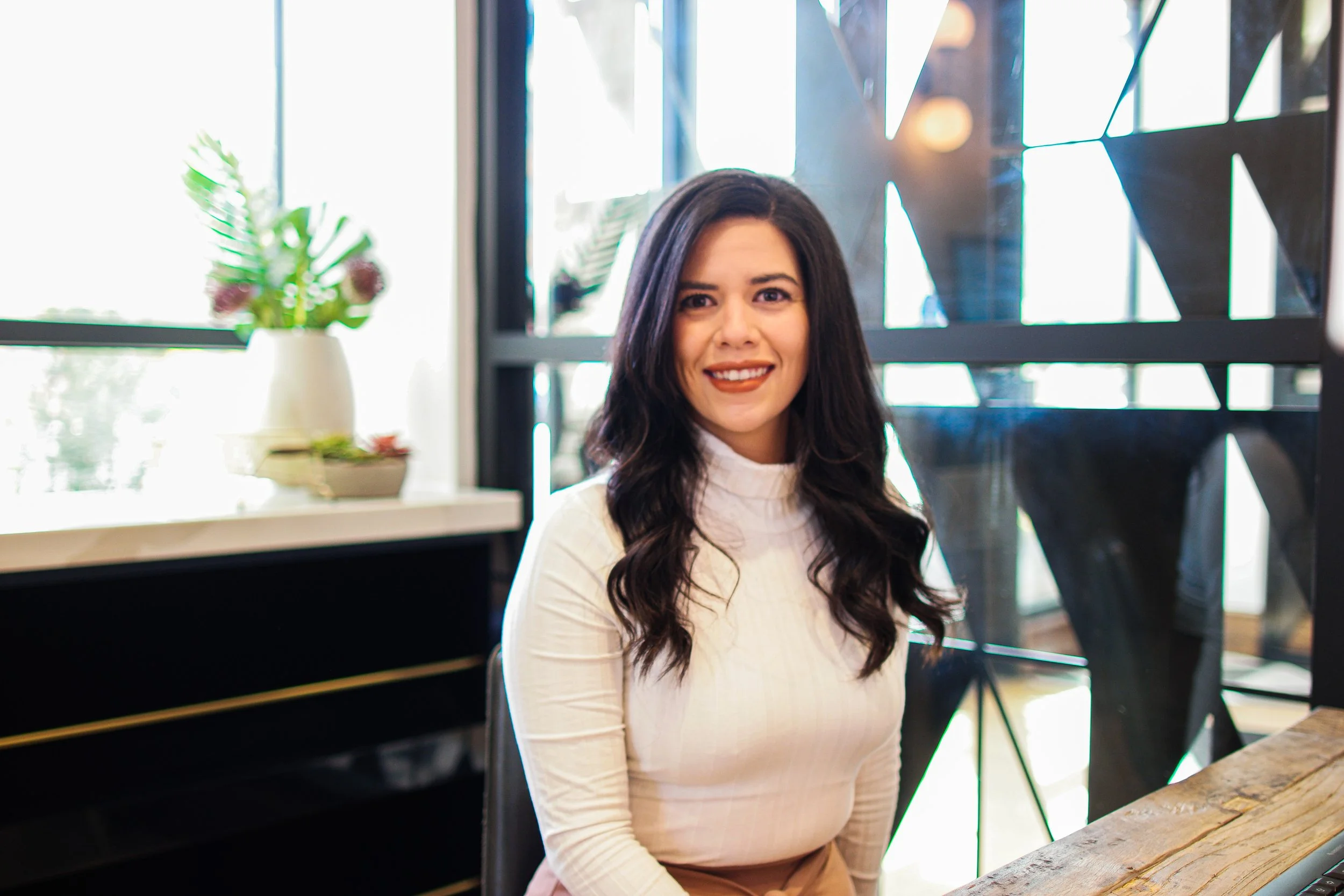 A professional portrait photographed in a modern office setting in Austin, Texas. The natural window light and relaxed posture create a polished yet approachable portrait ideal for personal branding, corporate profiles, and professional headshots.