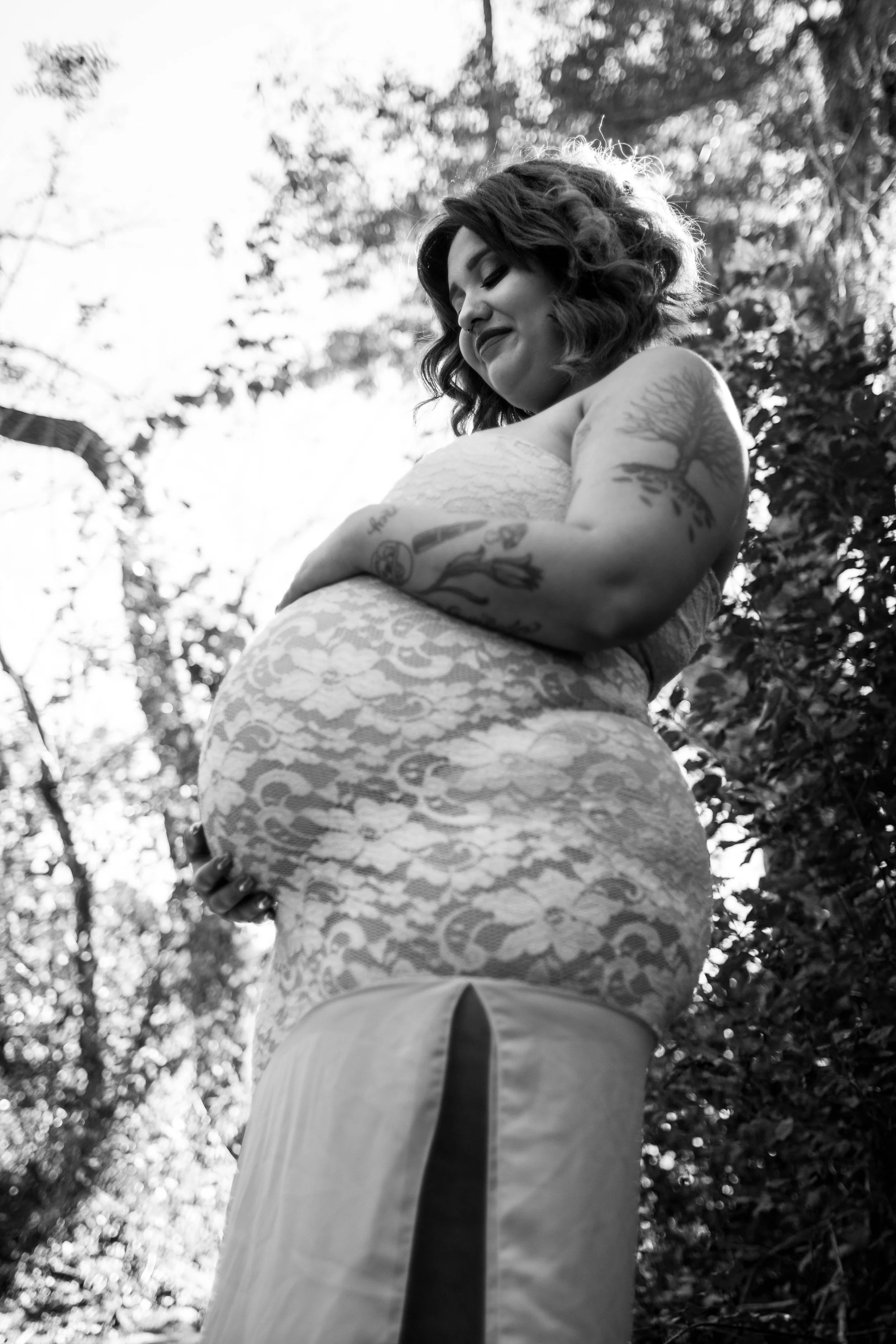 Low angle maternity portrait capturing the beauty of pregnancy during an outdoor maternity photography session in Austin, Texas by Caerus Multimedia.