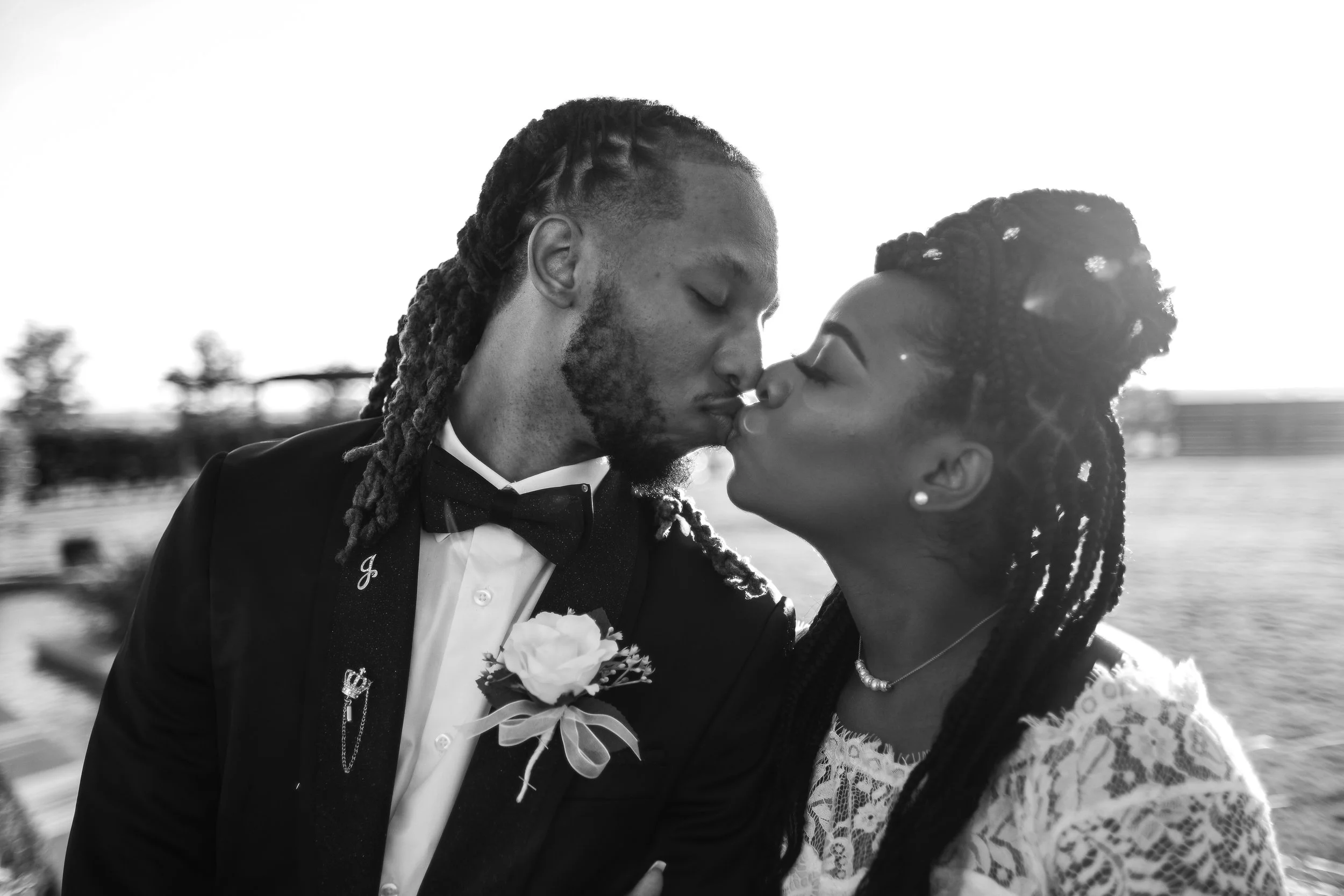 A timeless black-and-white portrait capturing the newlyweds sharing a kiss during golden hour. Photographed by Caerus Multimedia, this image highlights the intimate moments and artistic storytelling found in Austin wedding photography.