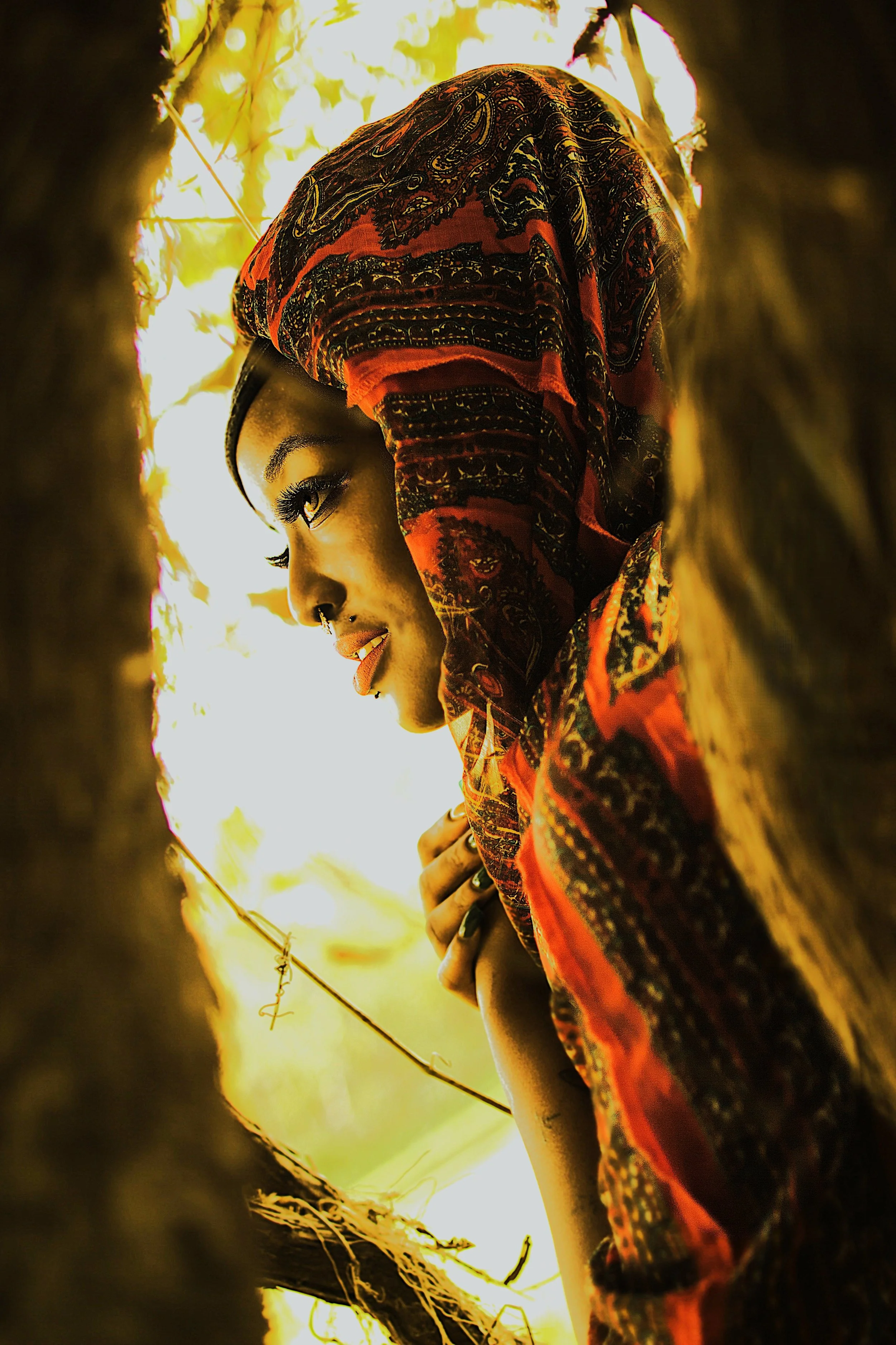 Framed by branches and filtered light, the Queen emerges from the shadows with unwavering presence. Her gaze reflects both vulnerability and strength, embodying the balance between reflection and power within the natural world.