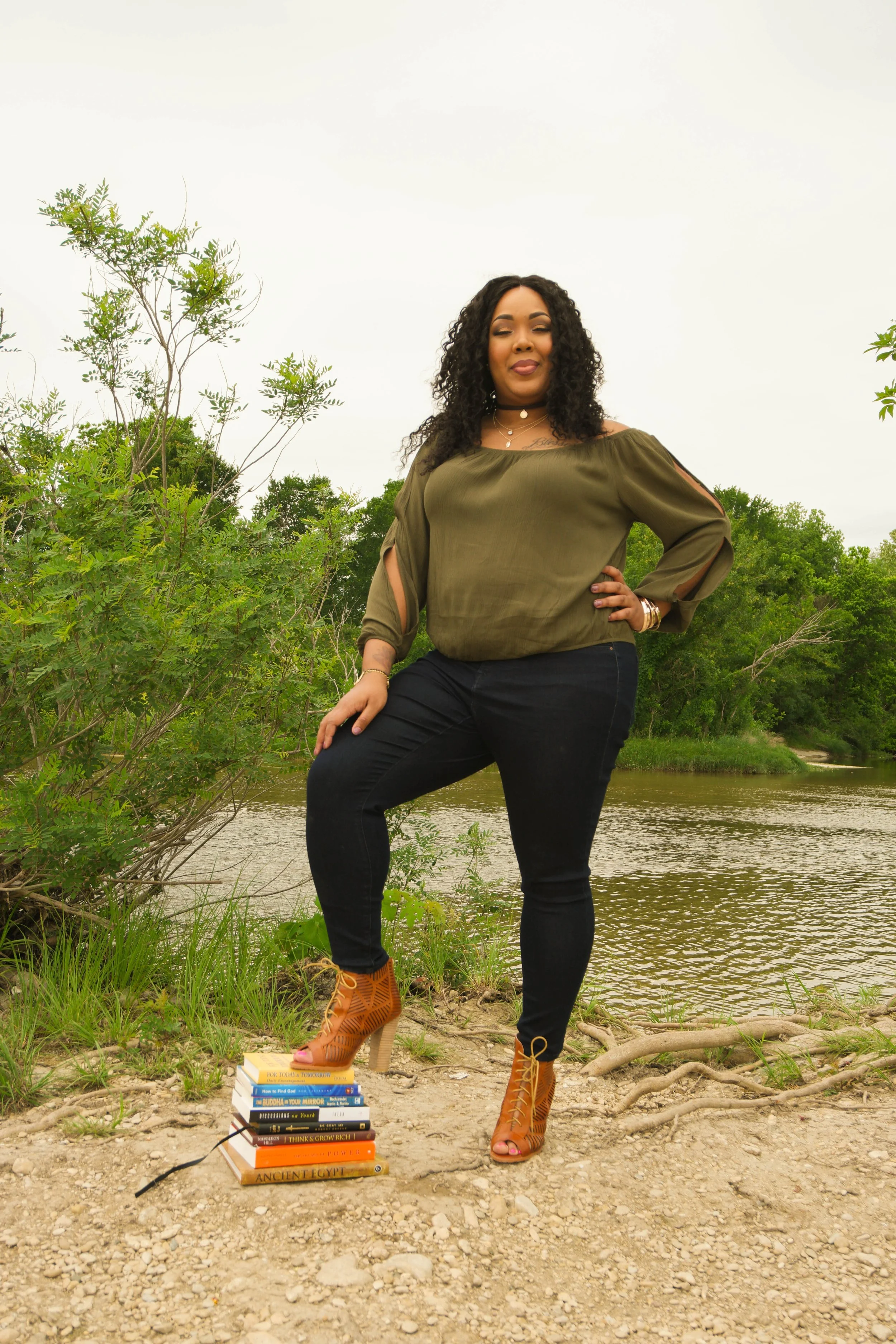 A lifestyle portrait framed by natural greenery, photographed during an outdoor session in Austin. The soft background and confident pose bring focus to the subject while maintaining a natural, organic aesthetic.