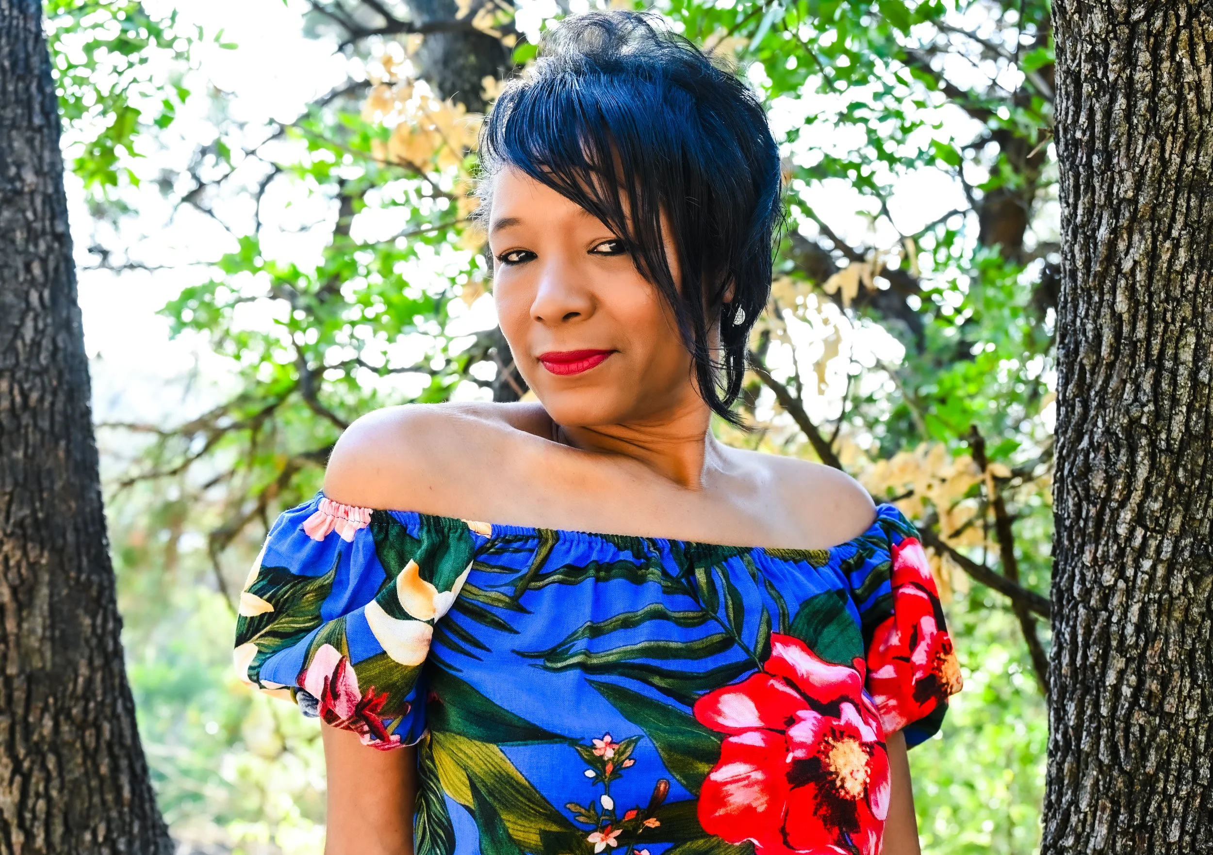 A vibrant outdoor portrait photographed in Austin with rich natural light and colorful surroundings. The combination of bold wardrobe and warm sunlight gives the portrait energy while still maintaining a natural, authentic feel.