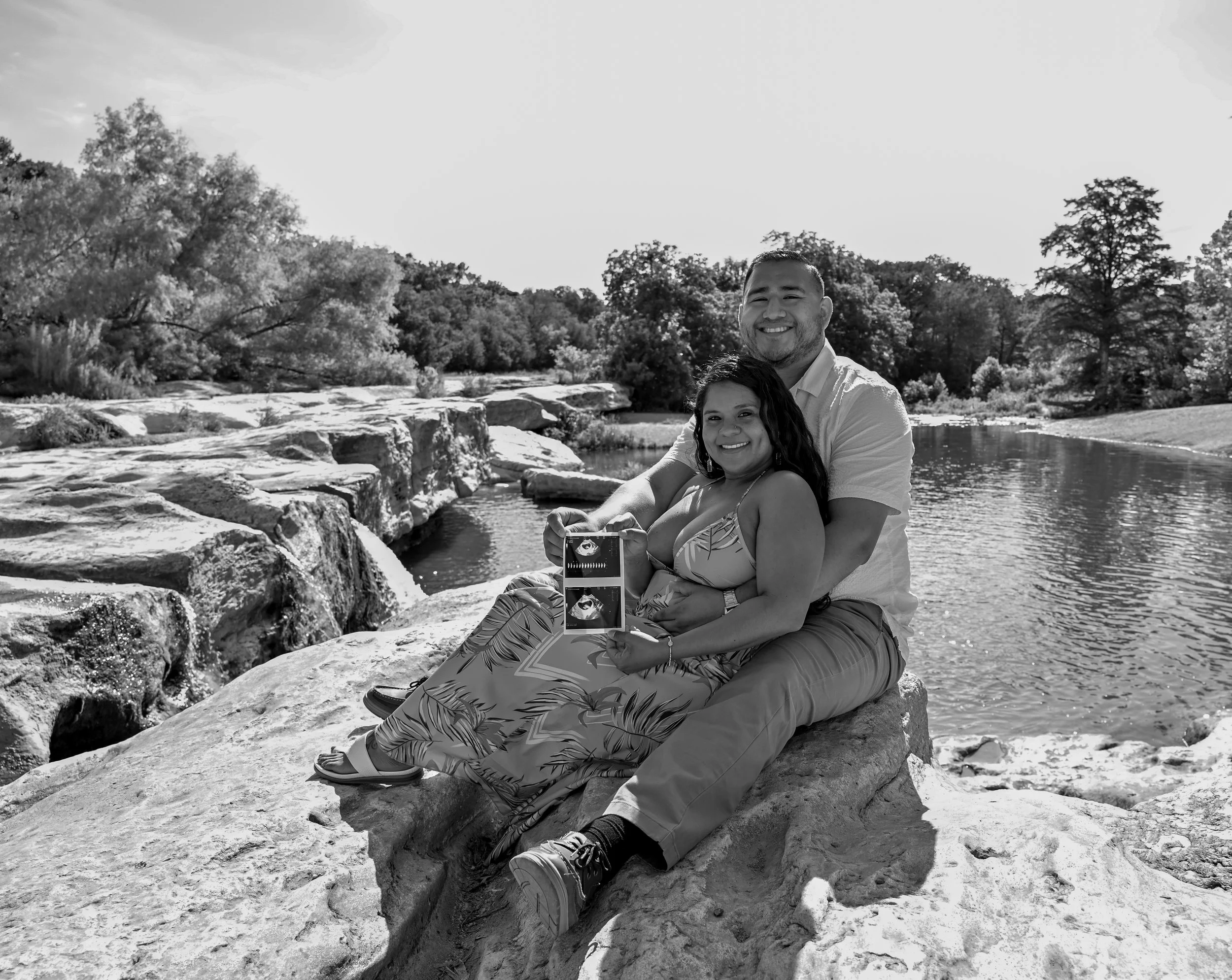 Expecting couple sharing ultrasound images during a maternity announcement photo session in Austin, Texas captured by maternity photographer Caerus Multimedia.