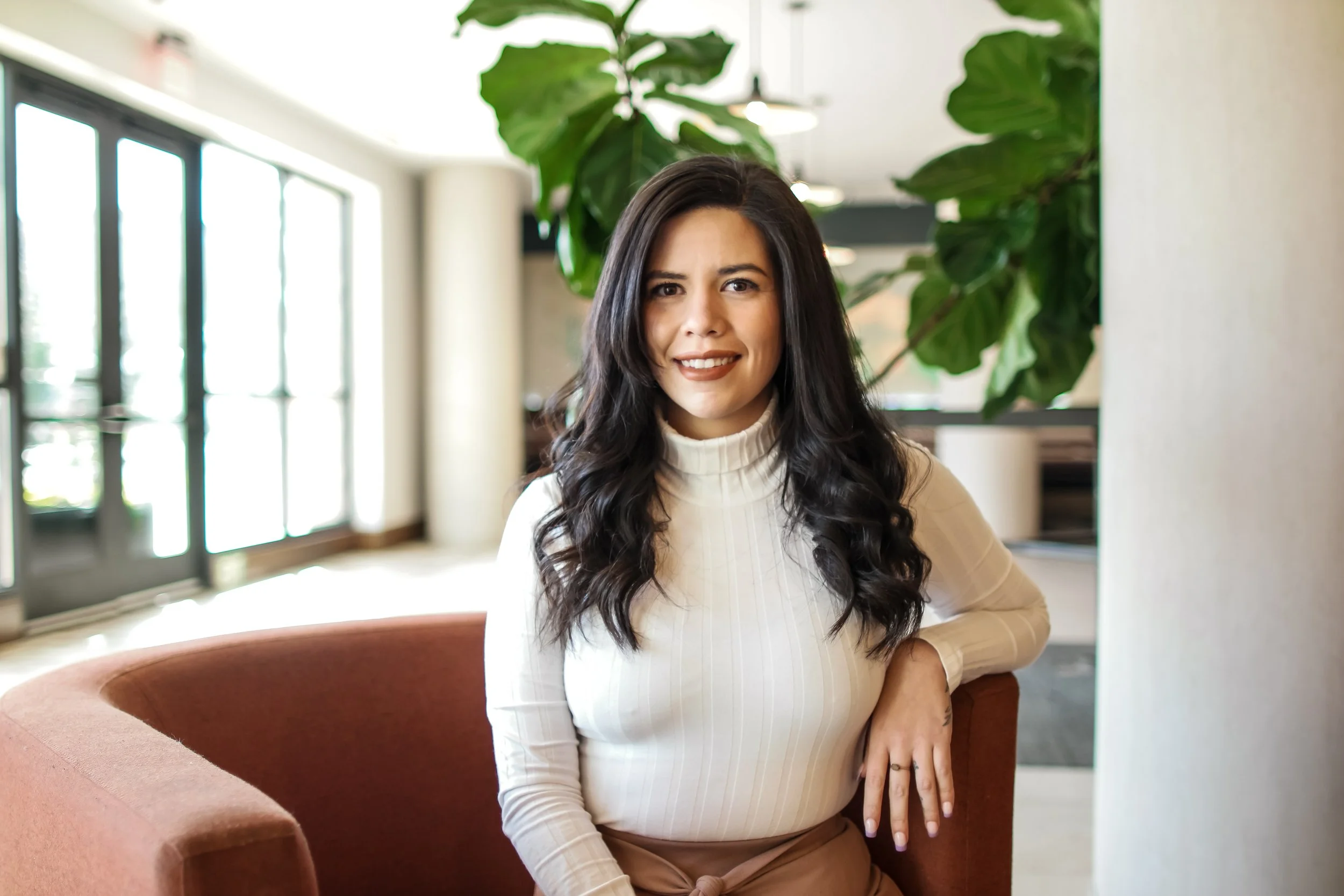 A professional branding portrait photographed in a modern interior setting in Austin, Texas. Soft natural light and a relaxed pose create a polished yet approachable portrait ideal for entrepreneurs, professionals, and personal branding photography.