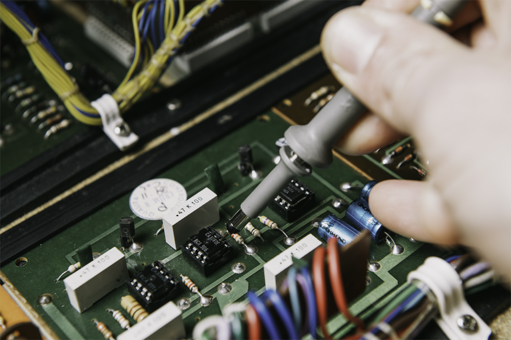 Un réparateur de synthétiseurs, boite à rythmes et claviers analogiques qui recherche la panne sur un instrument ancien