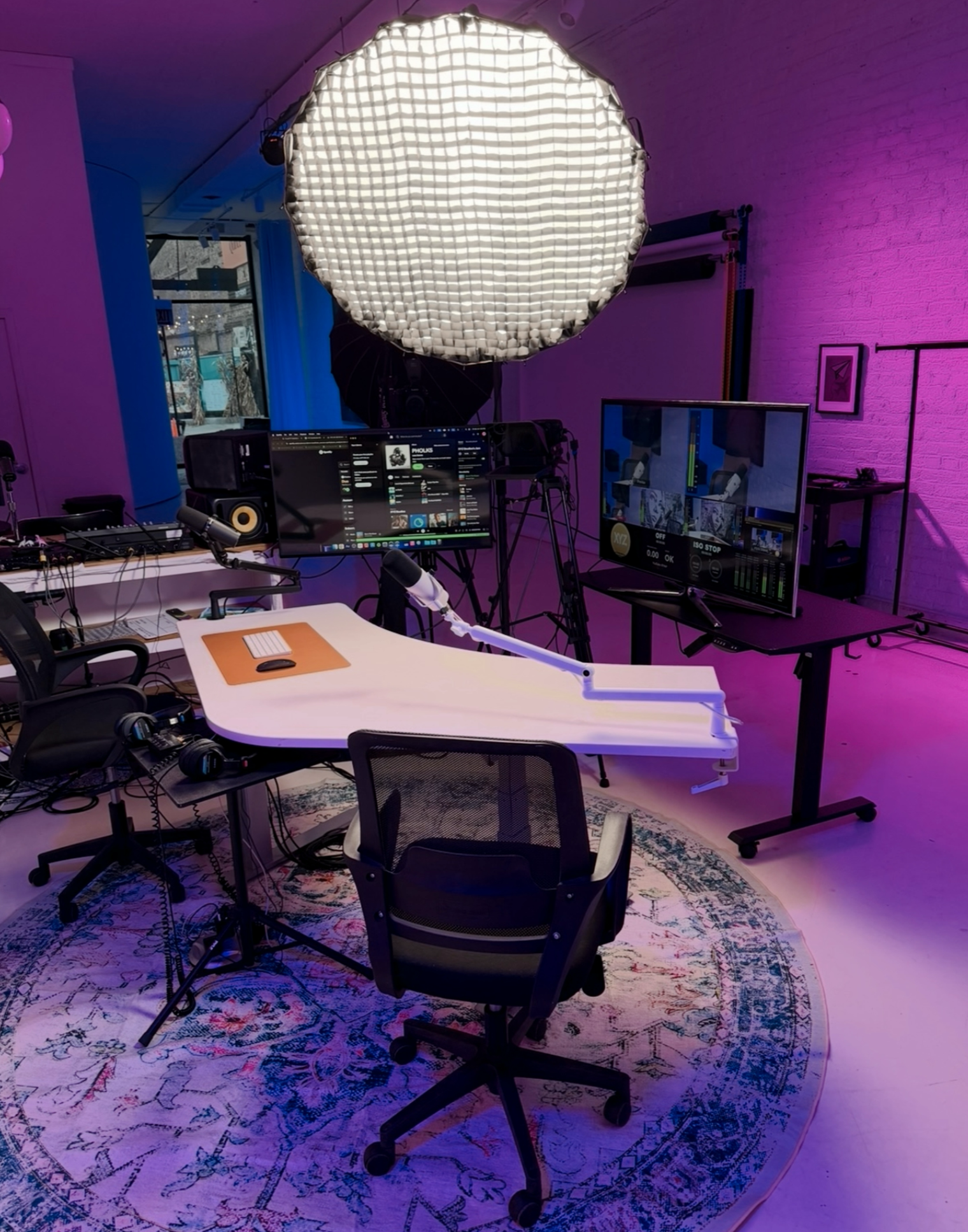 Podcast recording setup at XYZ Studios Chicago featuring microphones, cameras, monitors, headphones, and professional lighting inside the River North podcast studio.