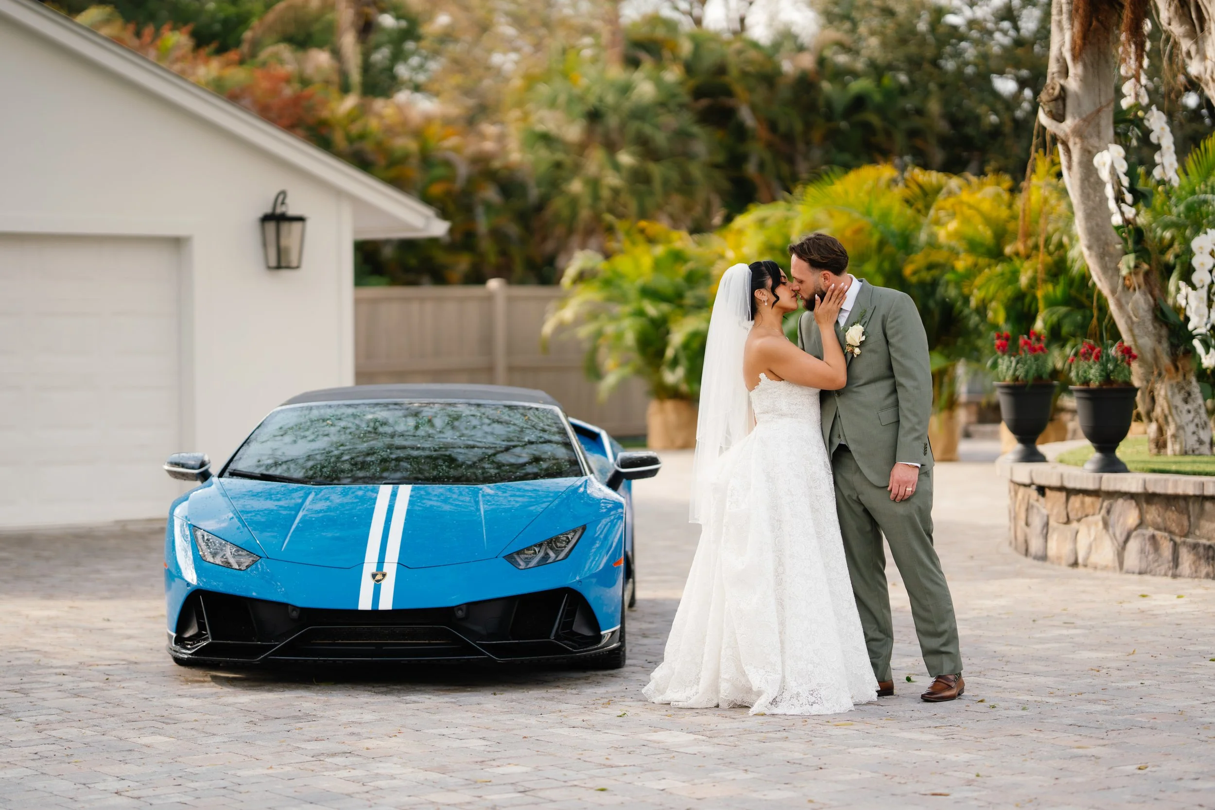 Bride and groom portrait beside luxury car during wedding day in South Florida