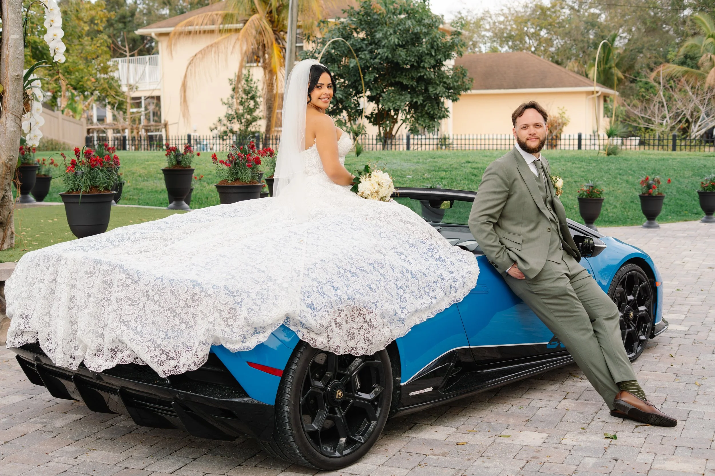 Bride sitting with wedding dress spread out during South Florida wedding portraits in garden setting