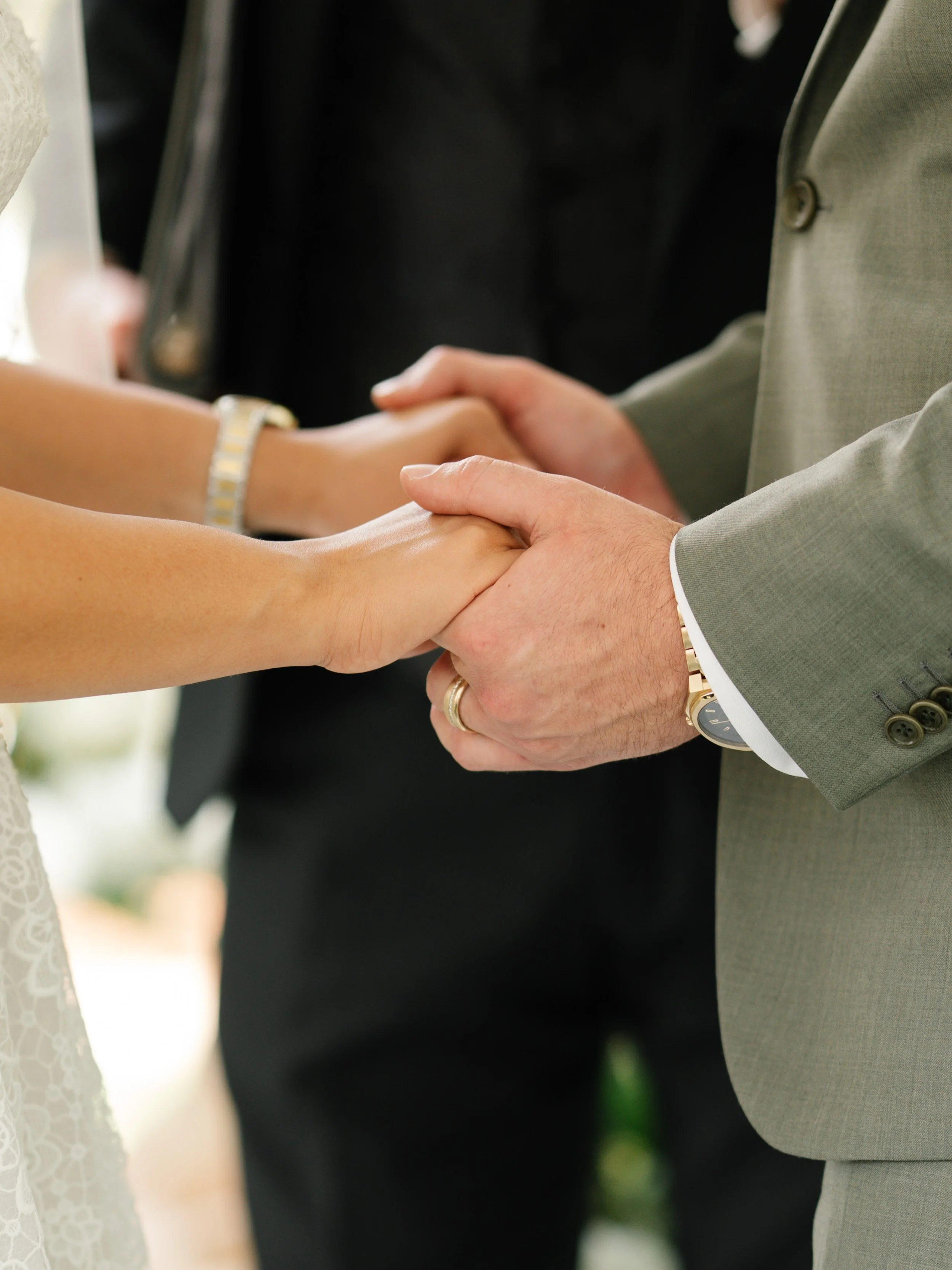 Close-up of bride and groom holding hands during wedding ceremony in South Florida