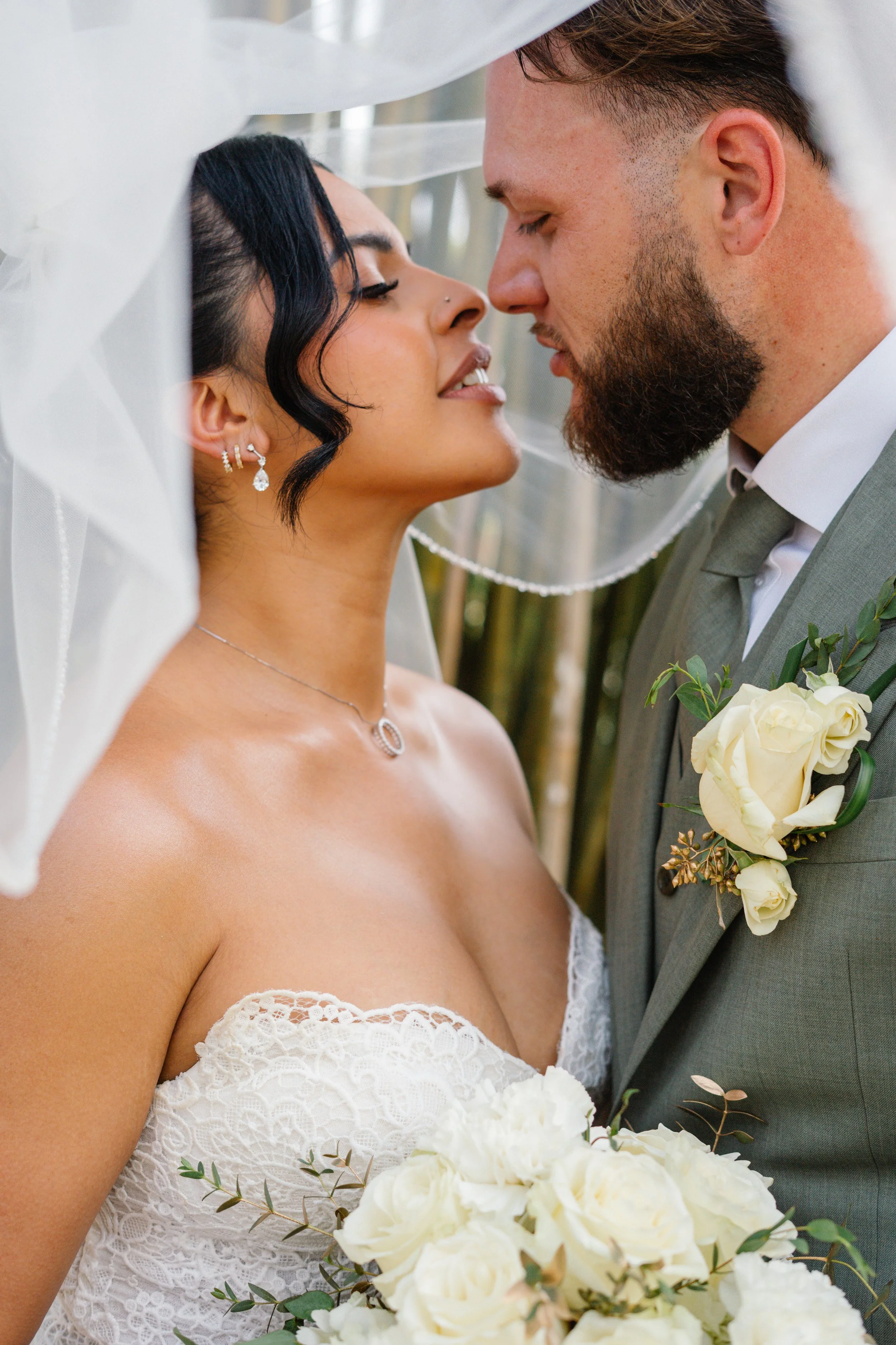 Close-up of bride and groom kissing under veil during romantic South Florida wedding moment