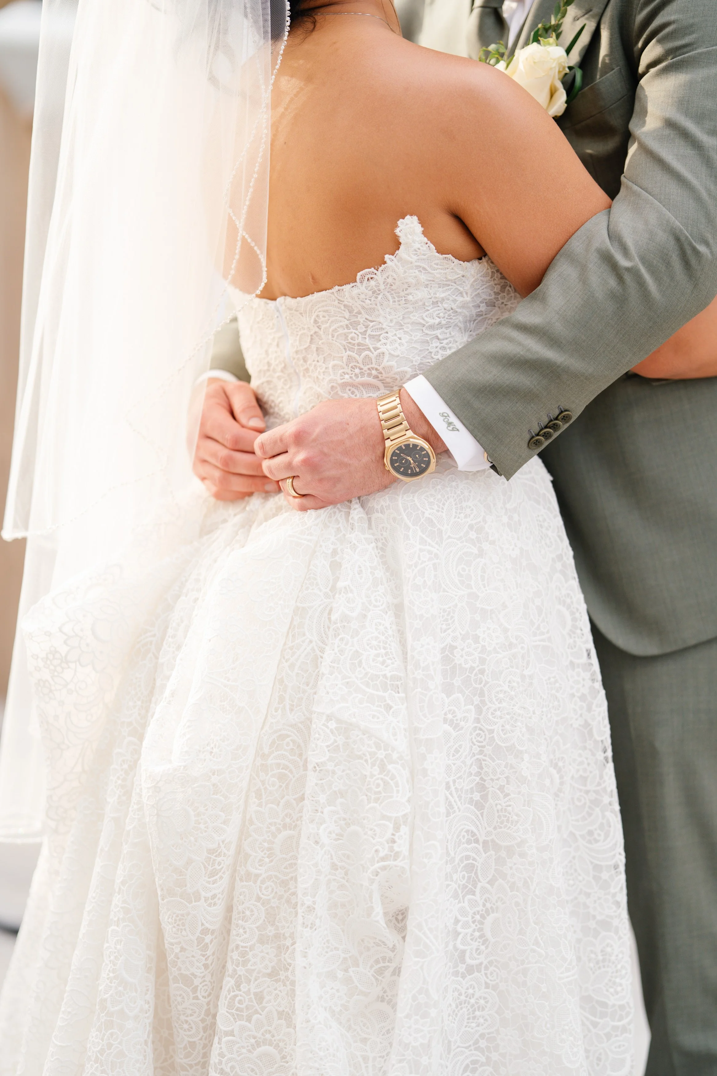 Close-up of bride and groom embracing with wedding dress detail during South Florida wedding portraits