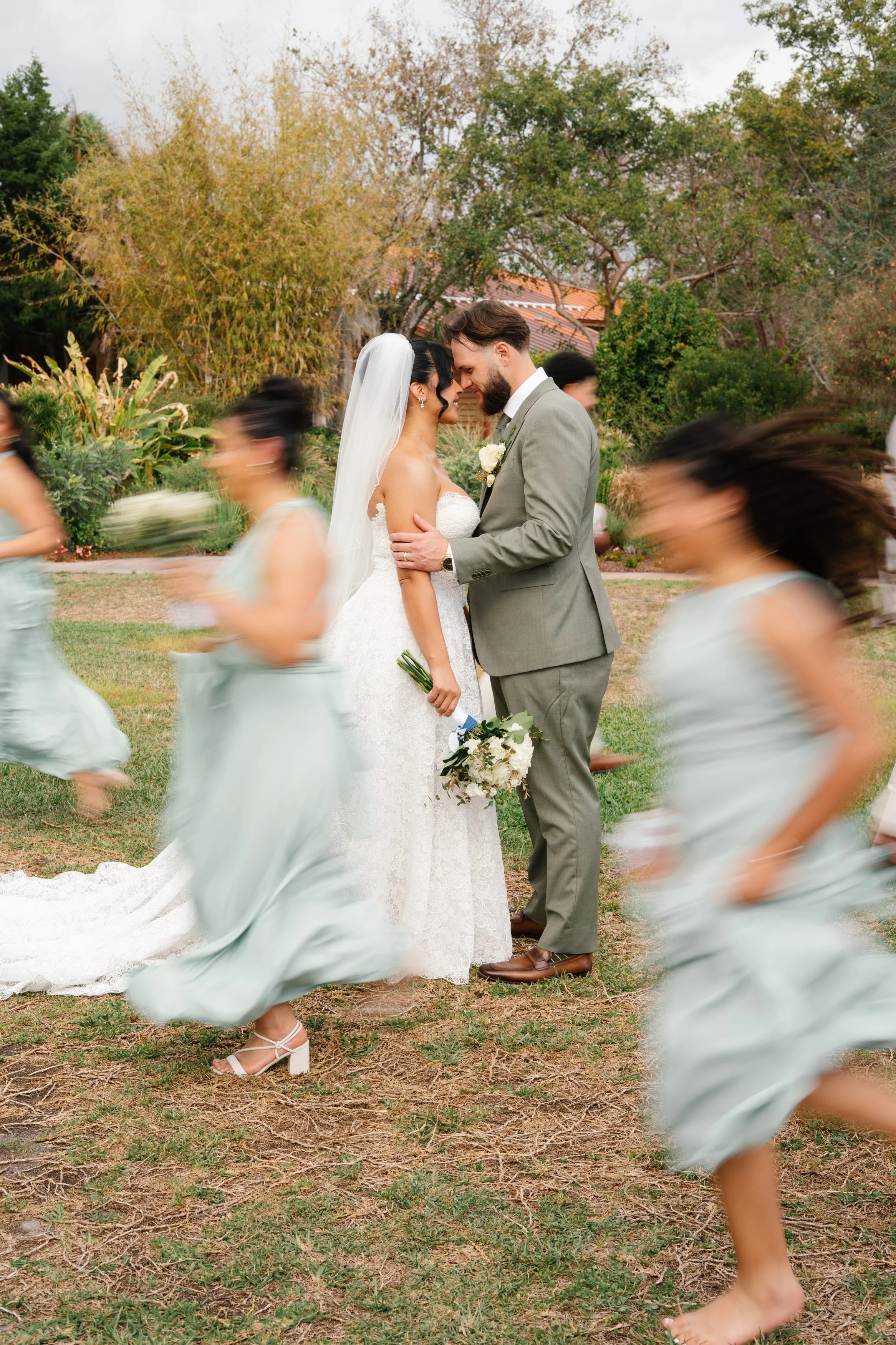 Bridesmaids running toward bride and groom in joyful candid moment during South Florida wedding