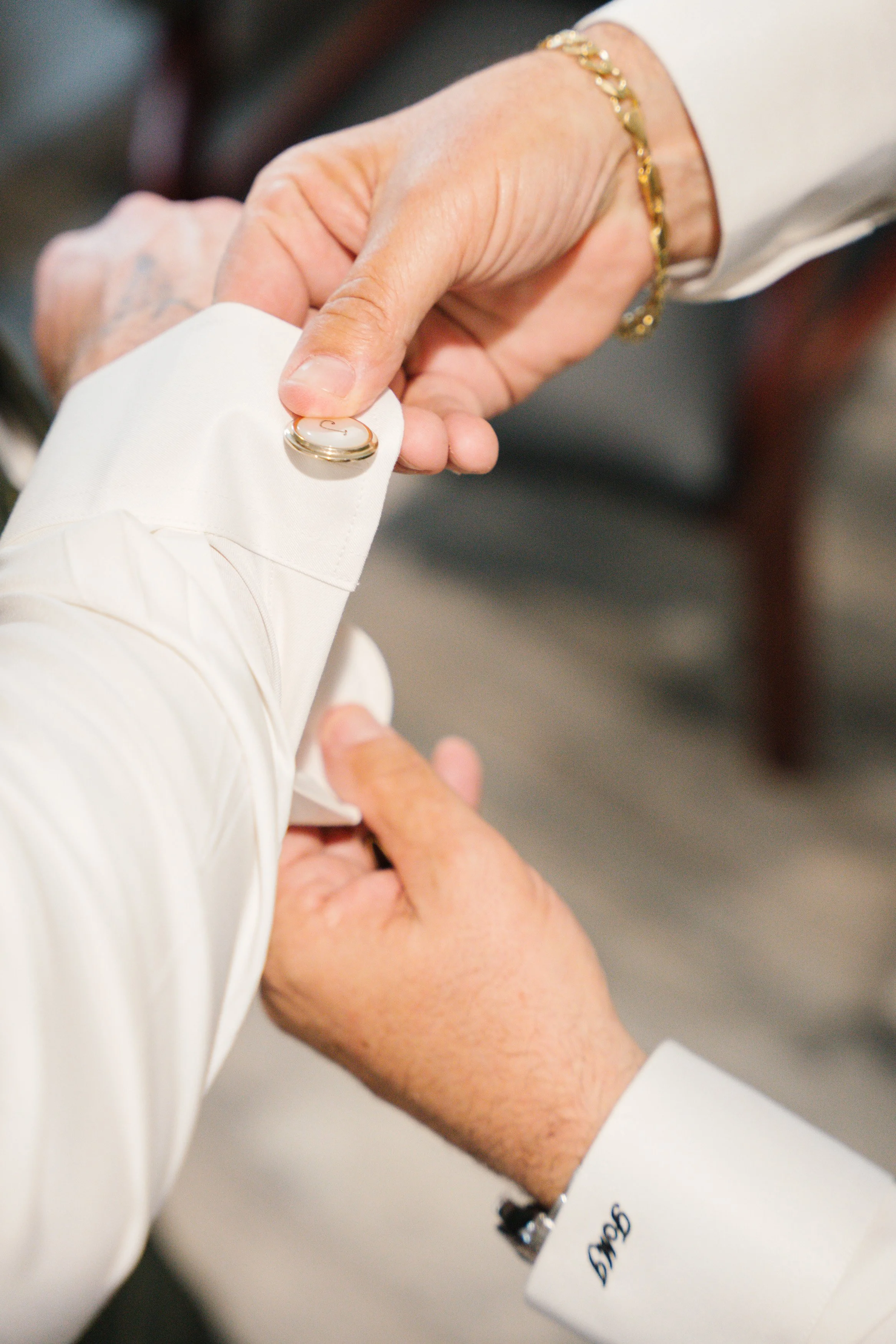 Close-up of groom getting into wedding tux during getting ready moments in South Florida