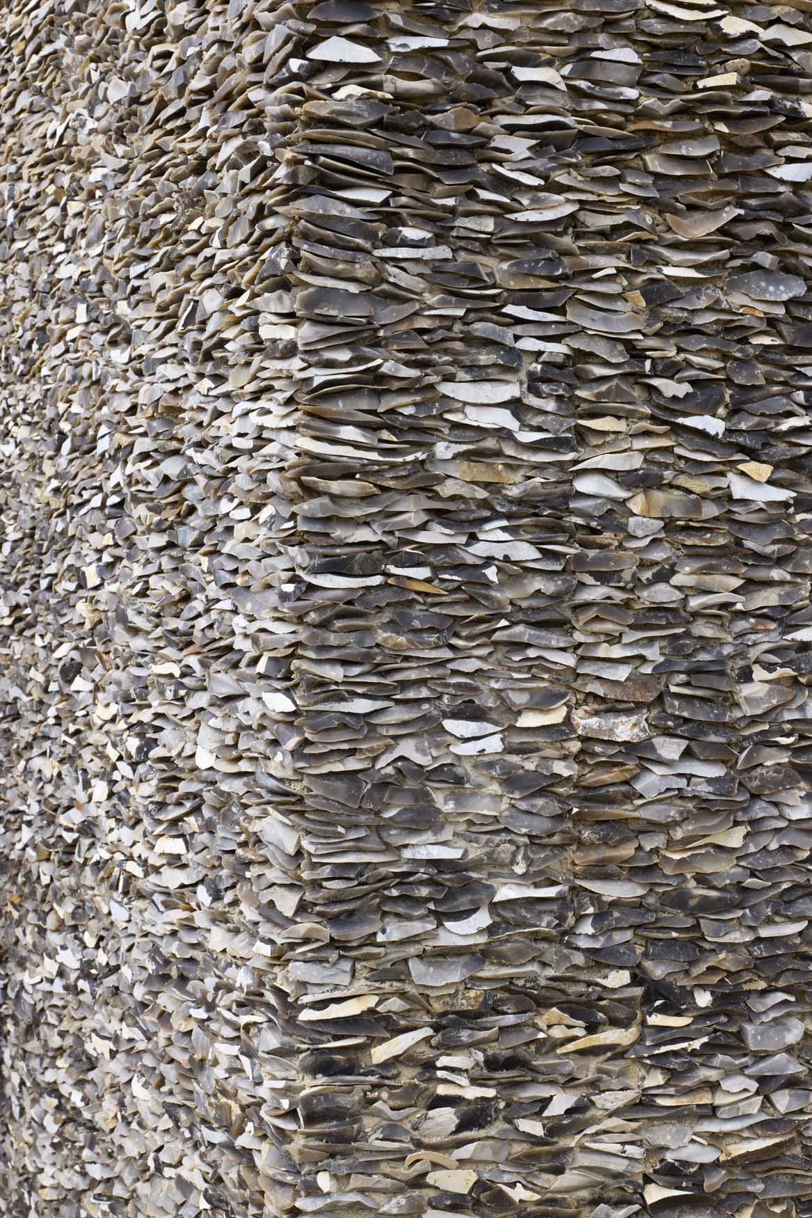 Close-up of a large stack of thin, irregularly shaped rocks or slate pieces used for landscaping or construction.