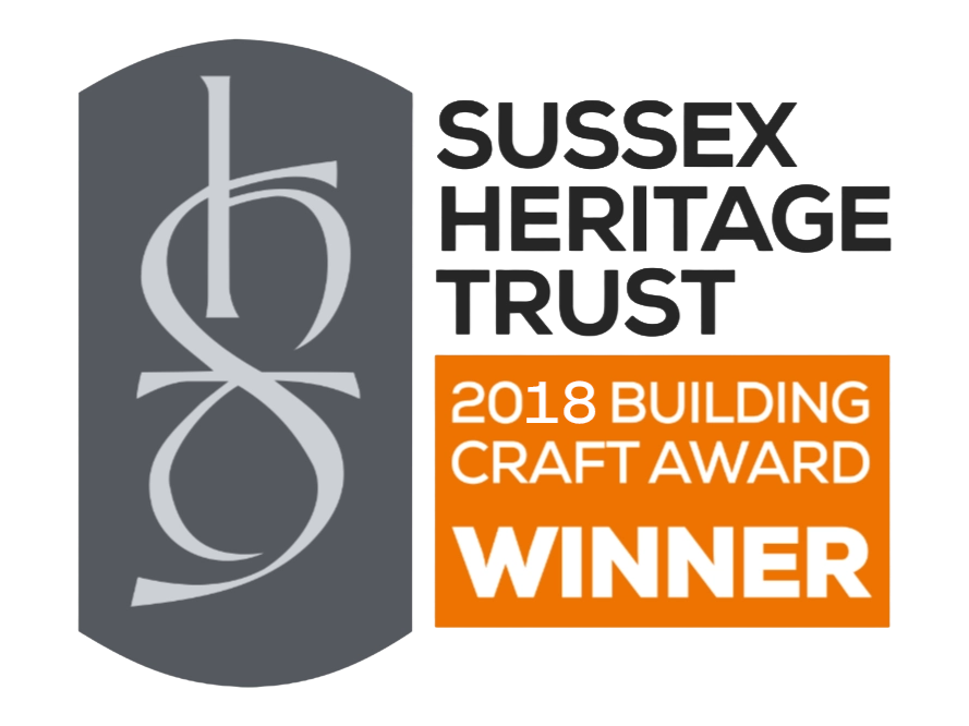 Sussex Heritage Trust 2018 Building Craft Award Winner badge featuring a stylized gray logo and text in black, white, and orange.