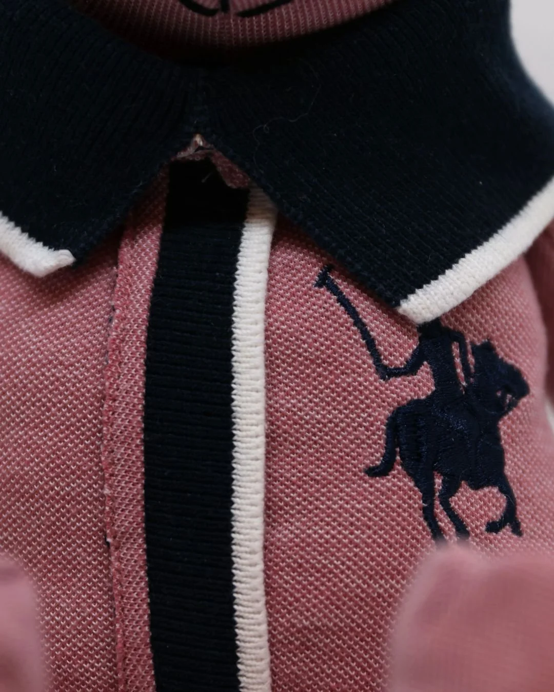 Detalle de una prenda de ropa con un logo de un elefante negro, color rosa y negro contrastando.
