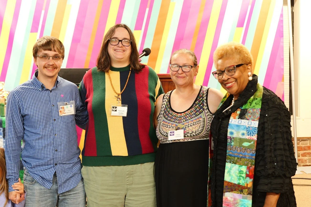 four people are standing together smiling