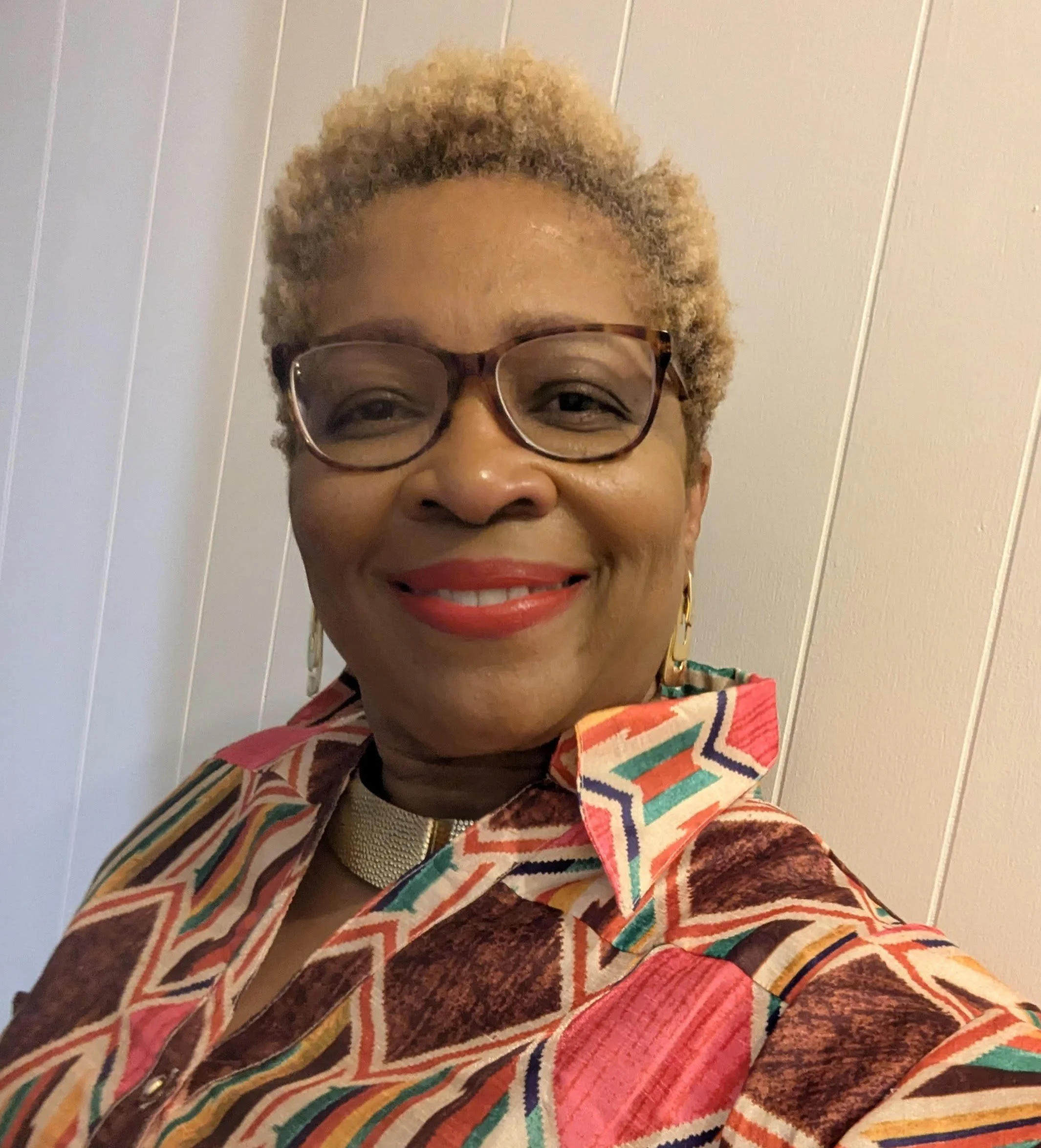 a Black woman in glasses smiling