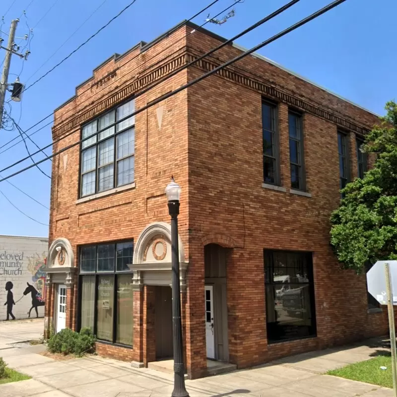 a boxy brick building in the city with power lines stretching in front of it