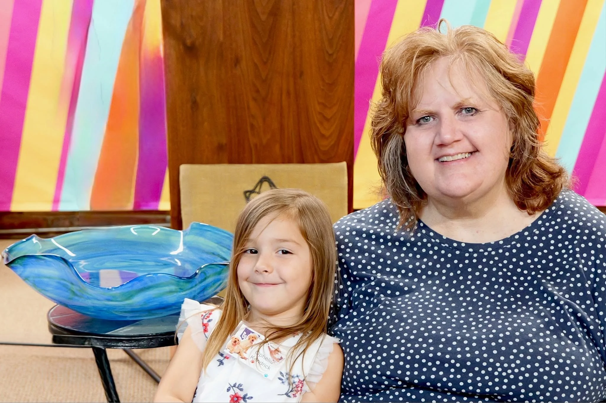 a woman and young girl are sitting together smiling