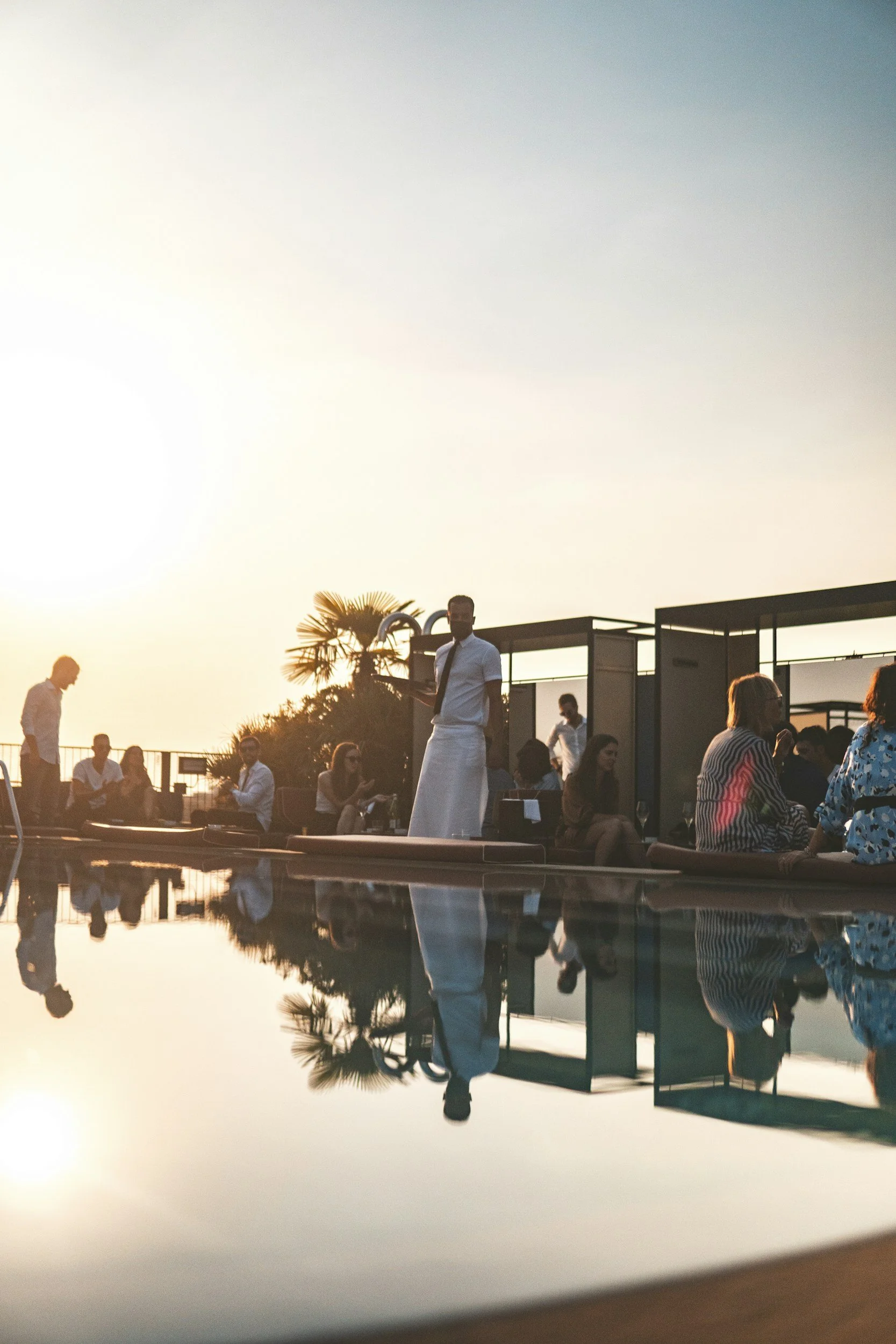 Guests enjoying an exclusive sunset pool party at a private