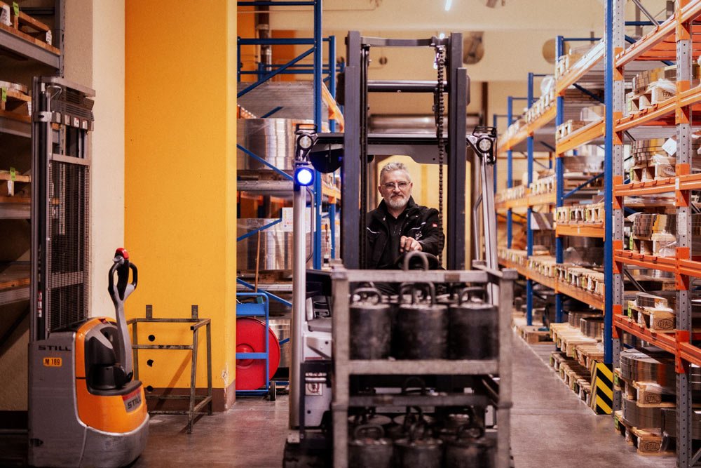 Mitarbeiter im Lager mit Stapler in Industriehalle