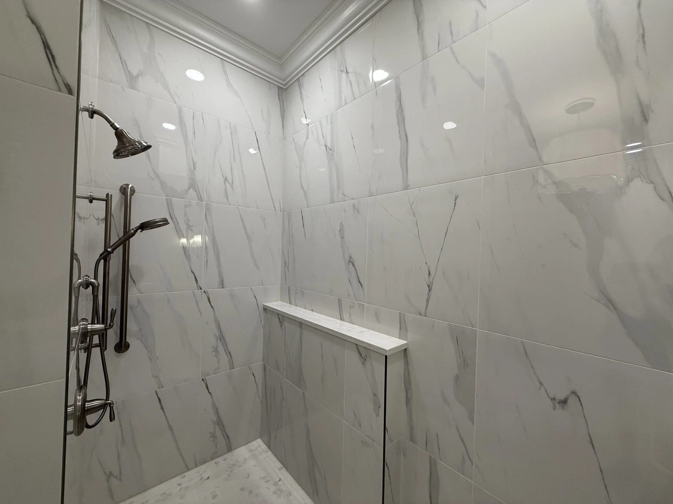 Marble-look porcelain shower with a bench