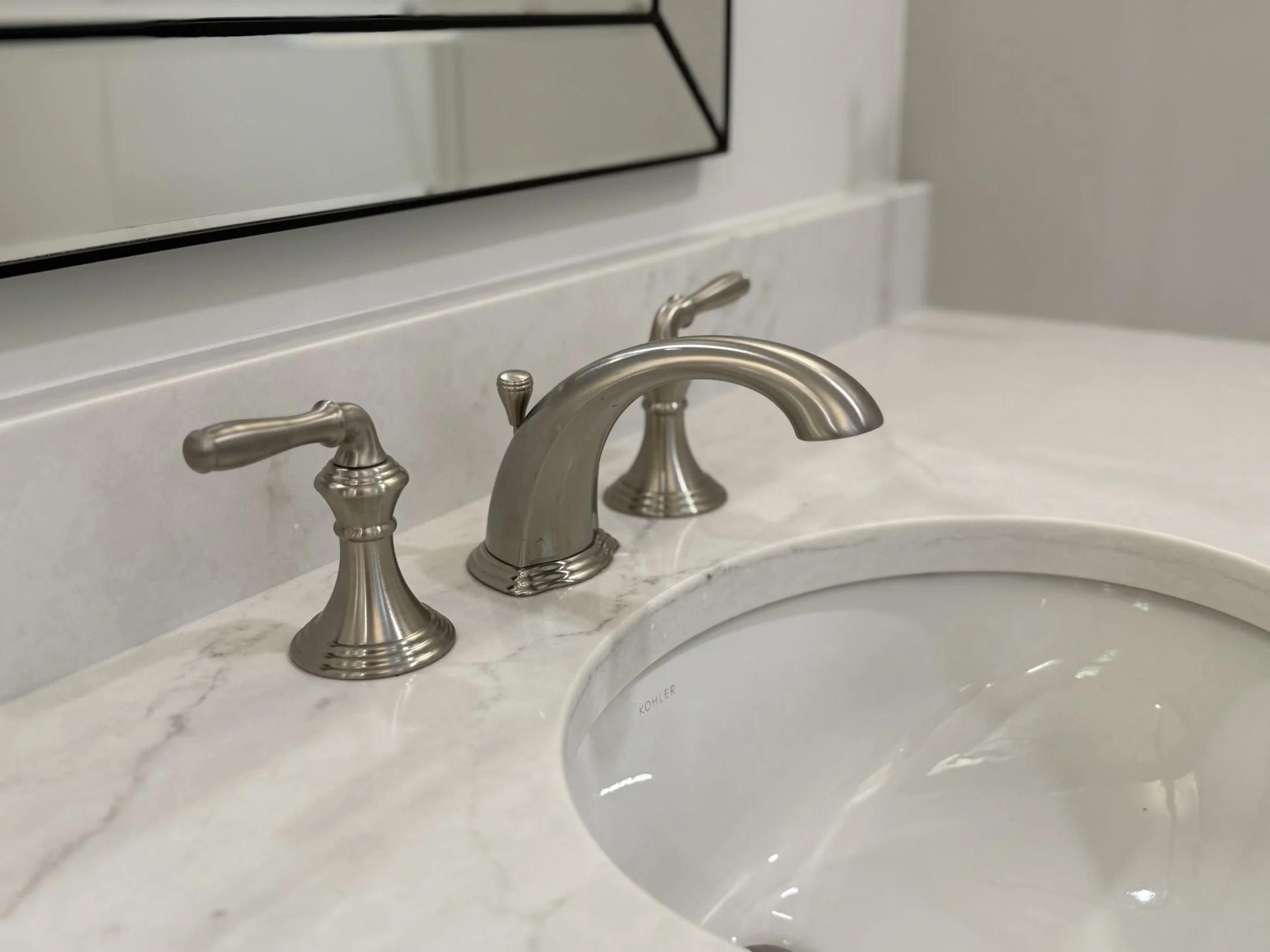 Brushed nickel faucet on a marble-look countertop