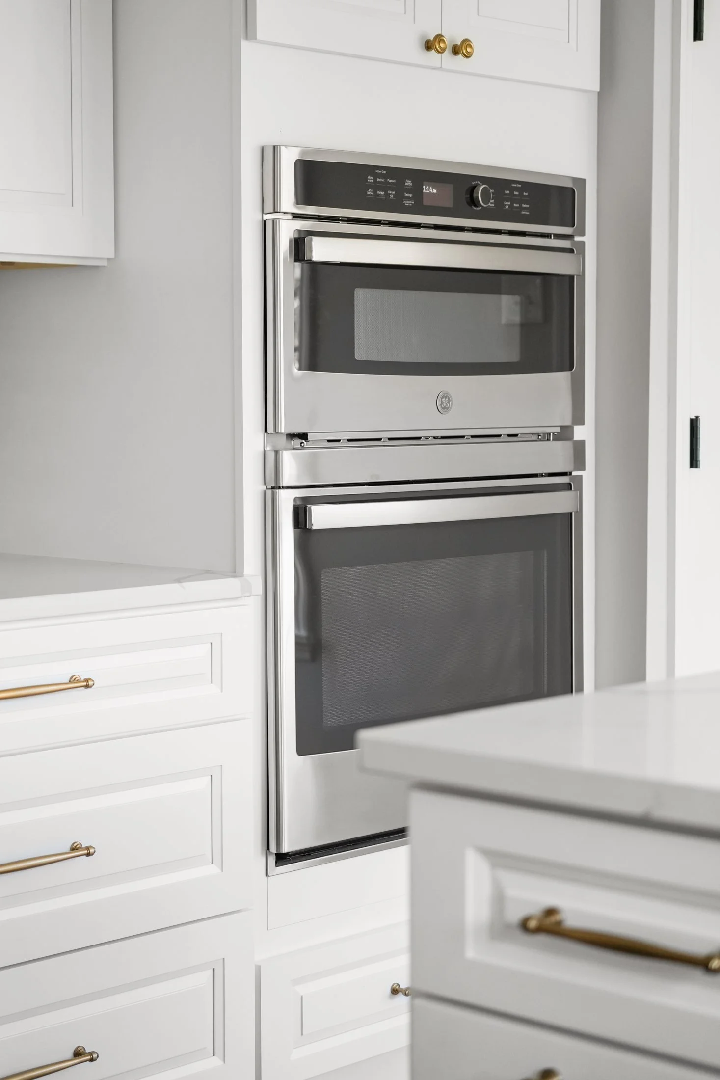 Stacked wall ovens in white cabinetry